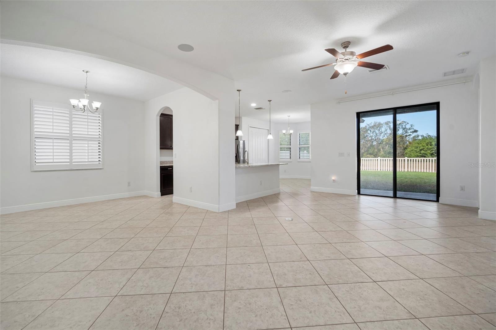 Living room looking out to the backyard with dining room and partial kitchen view.