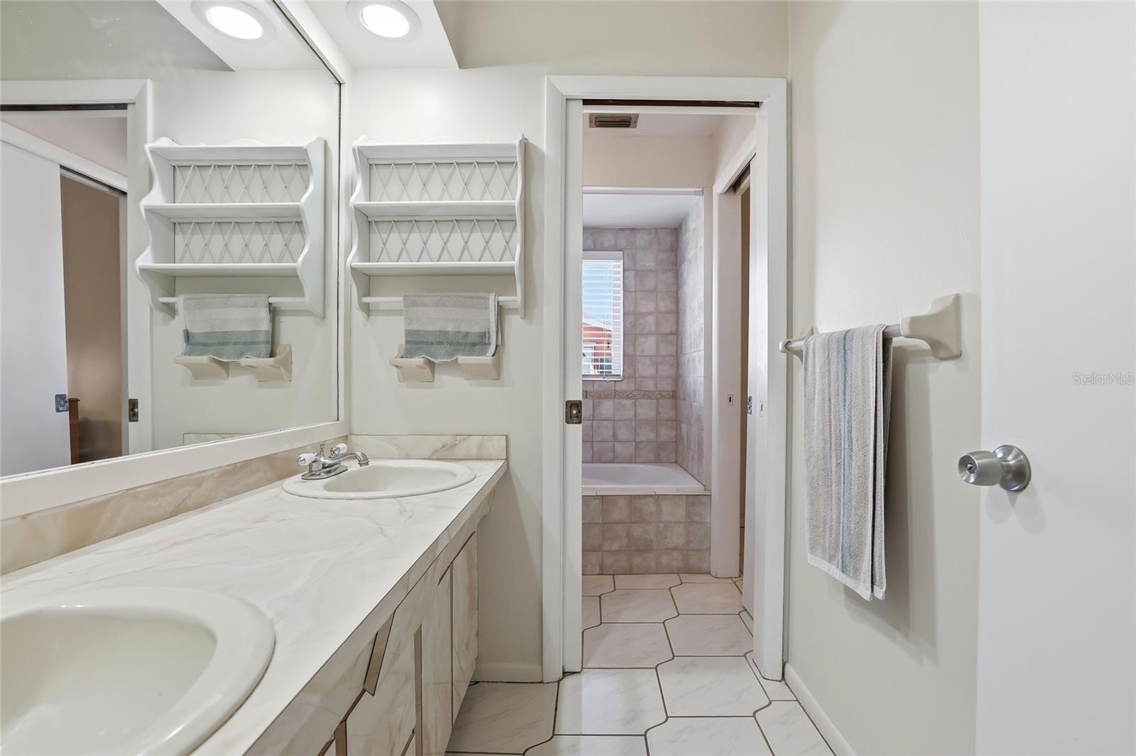 Adjoining bathroom with two sinks.