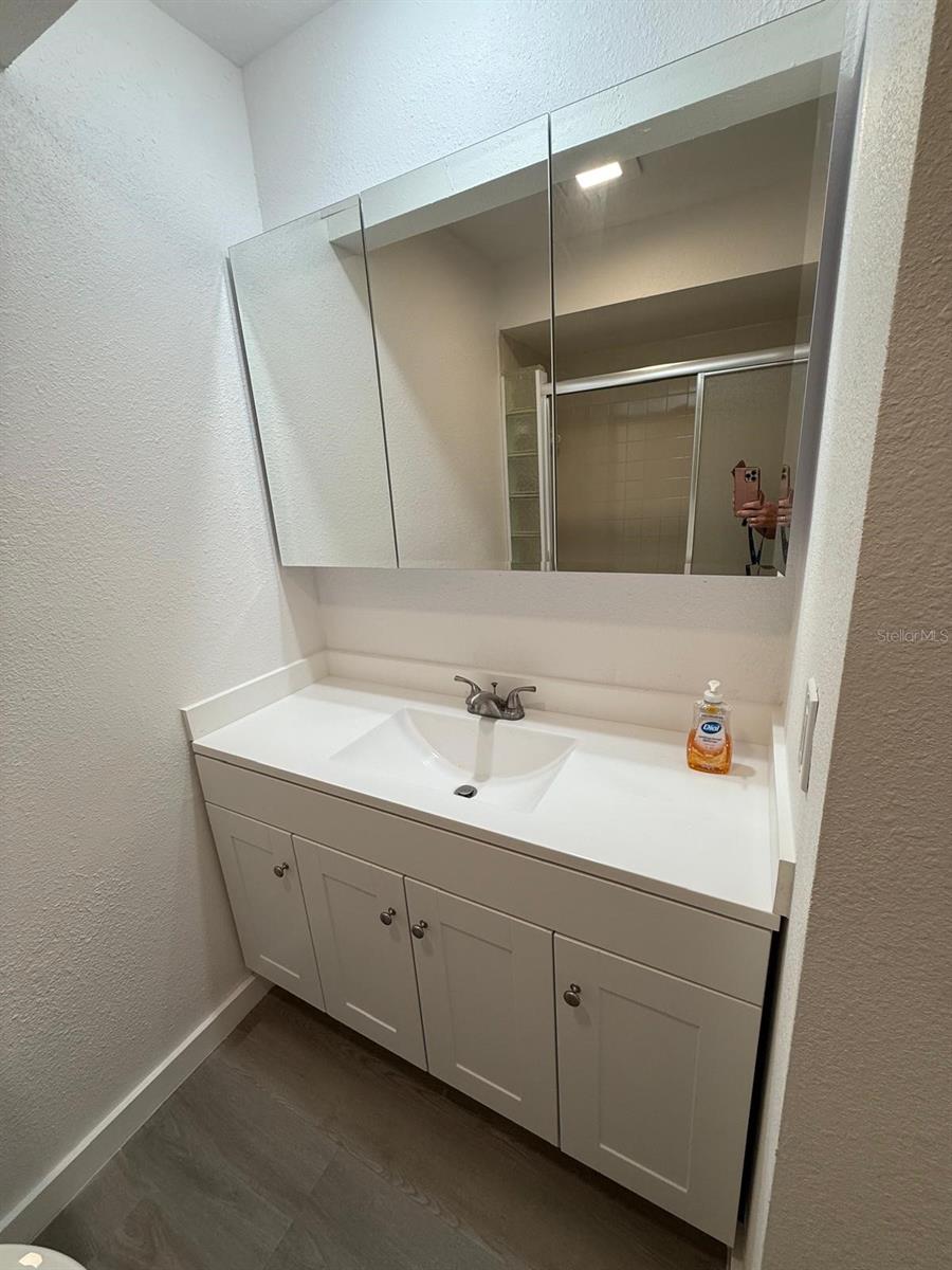 Full bath vanity, sink and mirror with well thought-out lighting.