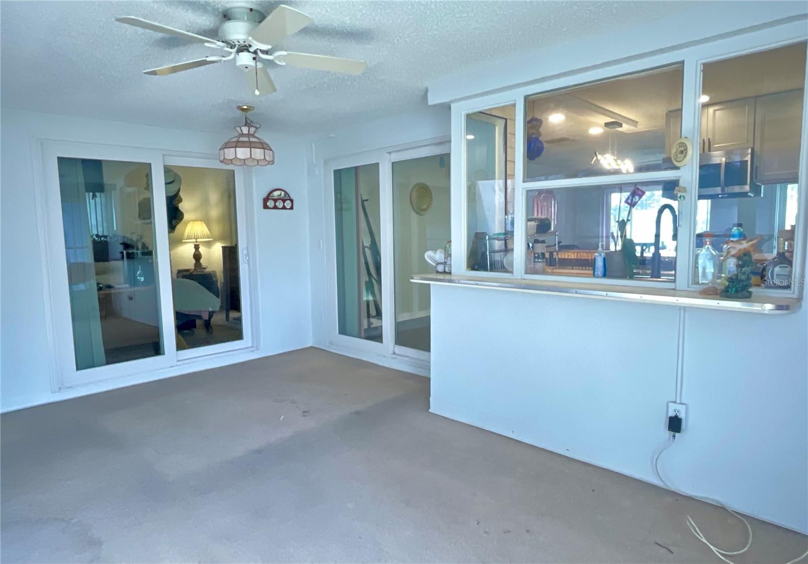 Florida room view towards kitchen and primary bedroom