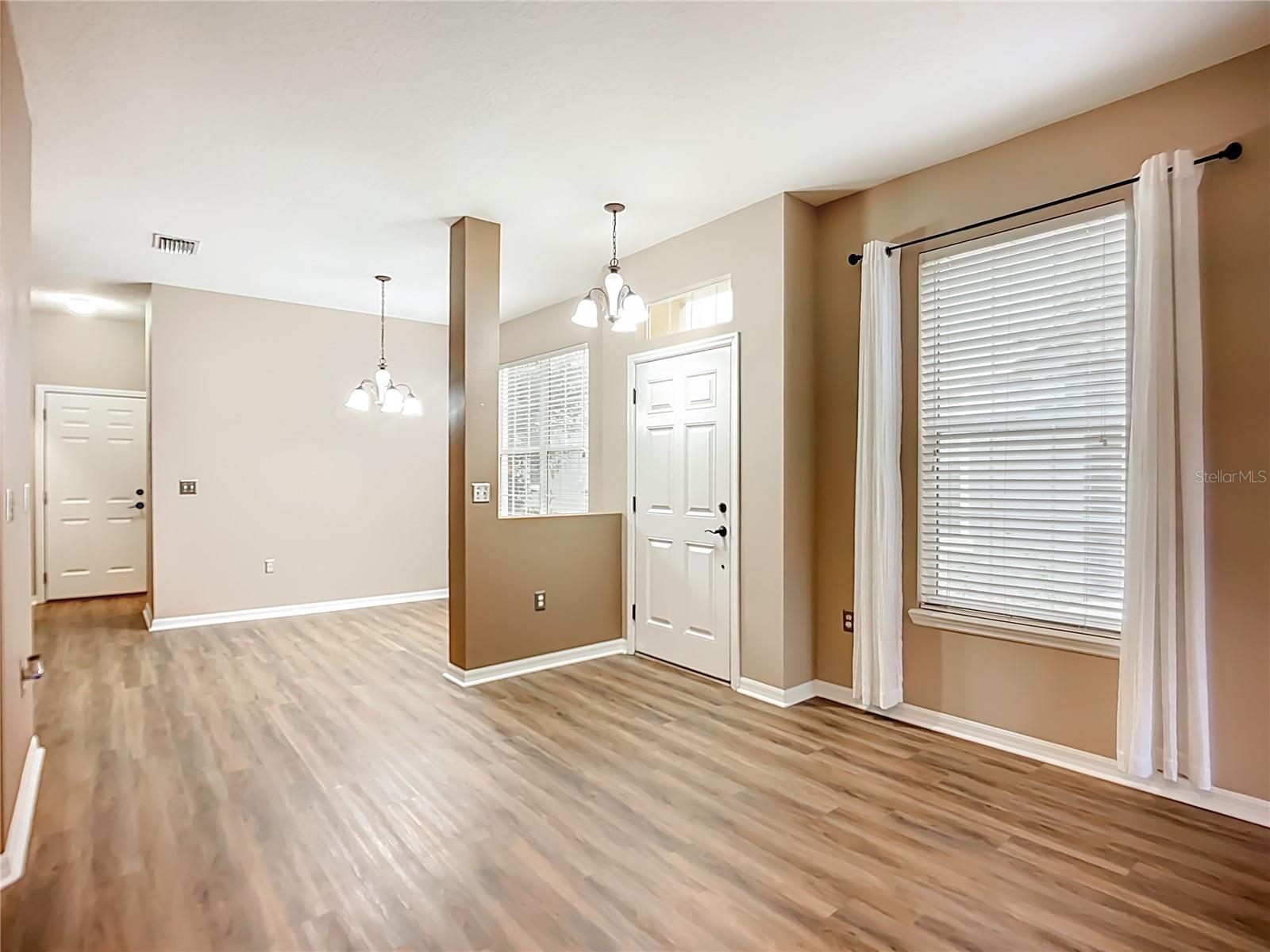 Living room with formal dining area, 1/2 bath, and laundry room beyond.