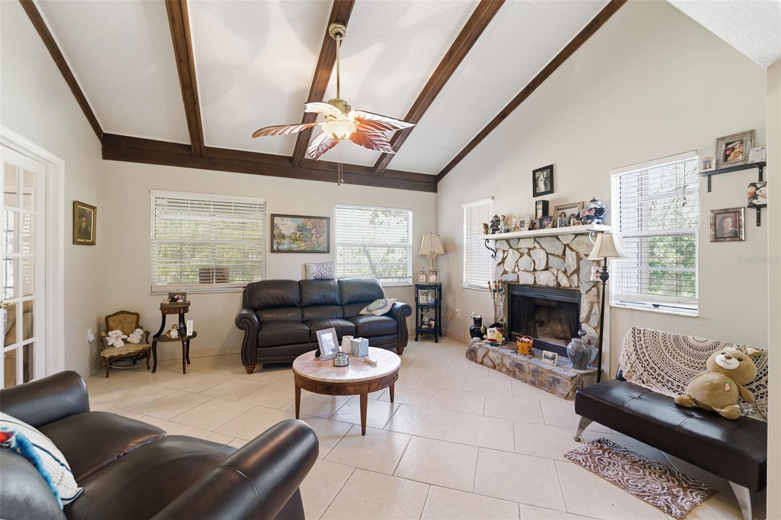 Open living room with high ceilings and a beautiful stone fireplace.