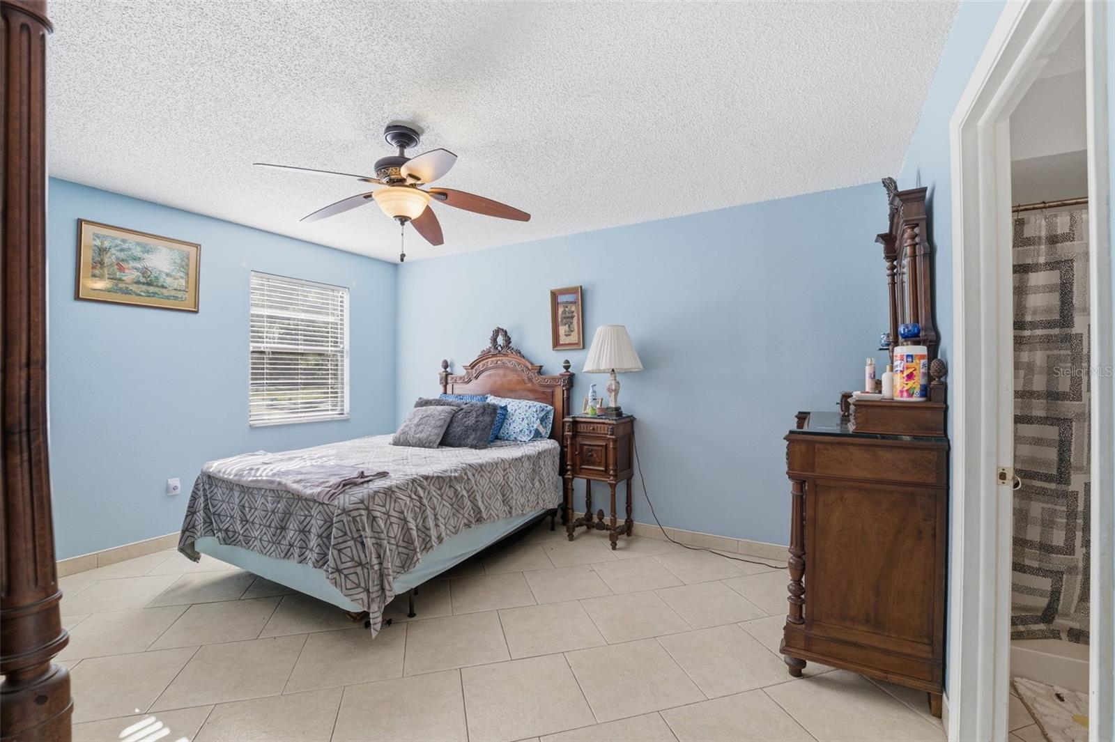 Bright primary bedroom featuring tile floors and plenty of natural light.