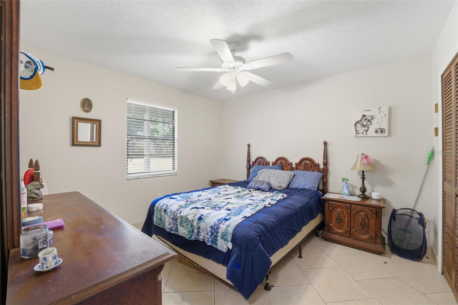 Inviting secondary bedroom featuring easy-care tile flooring and a sunny window.
