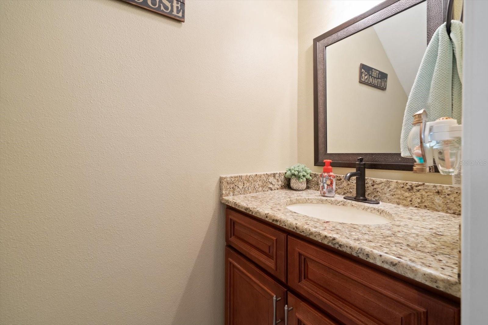 The half-bath for guests is located beneath the stairs on the first level for ease of access.