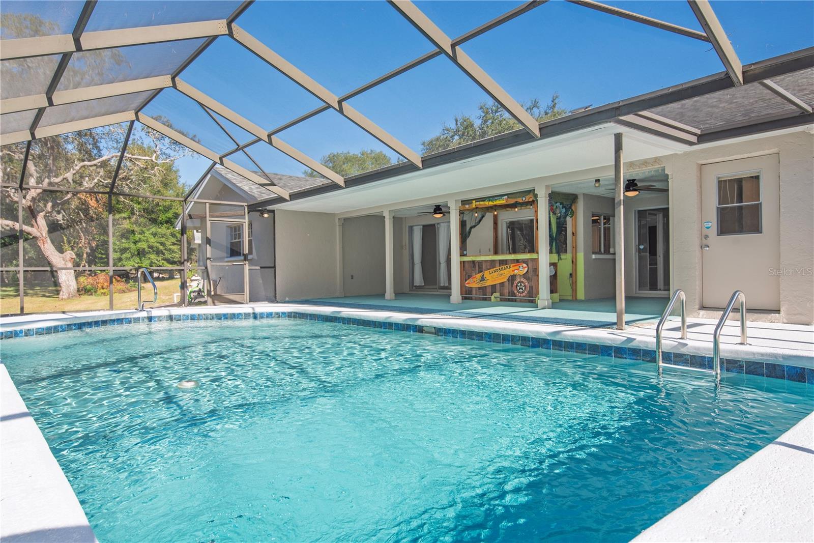 Private screen pool and covered lanai with tiki bar.