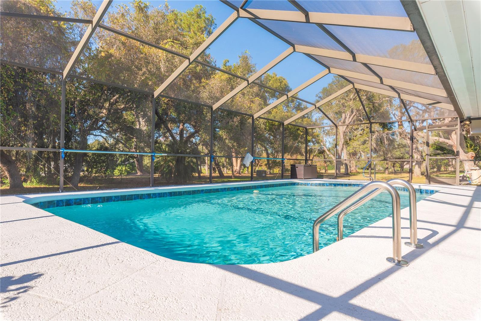 Private swimming pool and screen lanai with covered patio.