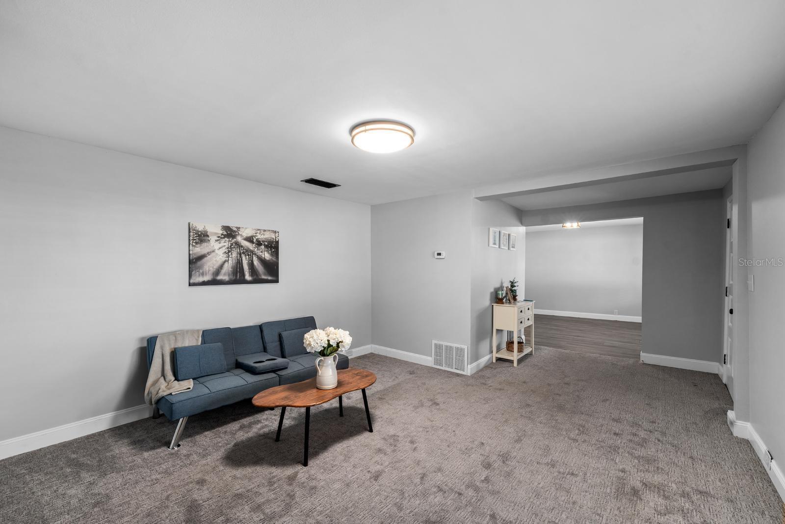 The living room has a stone electric fireplace, fresh paint, new lighting, new window blinds, updated 5-1/2' baseboards, and 18-month old carpet.