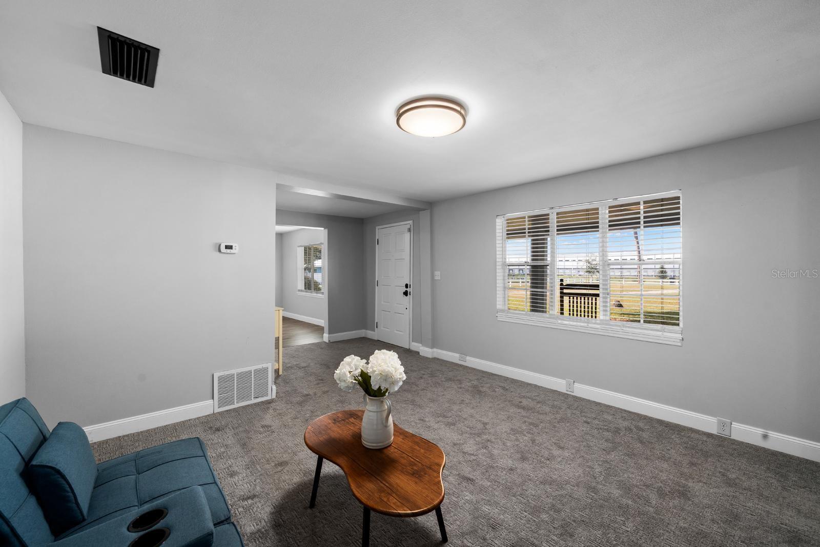 The living room has a stone electric fireplace, fresh paint, new lighting, new window blinds, updated 5-1/2' baseboards, and 18-month old carpet.