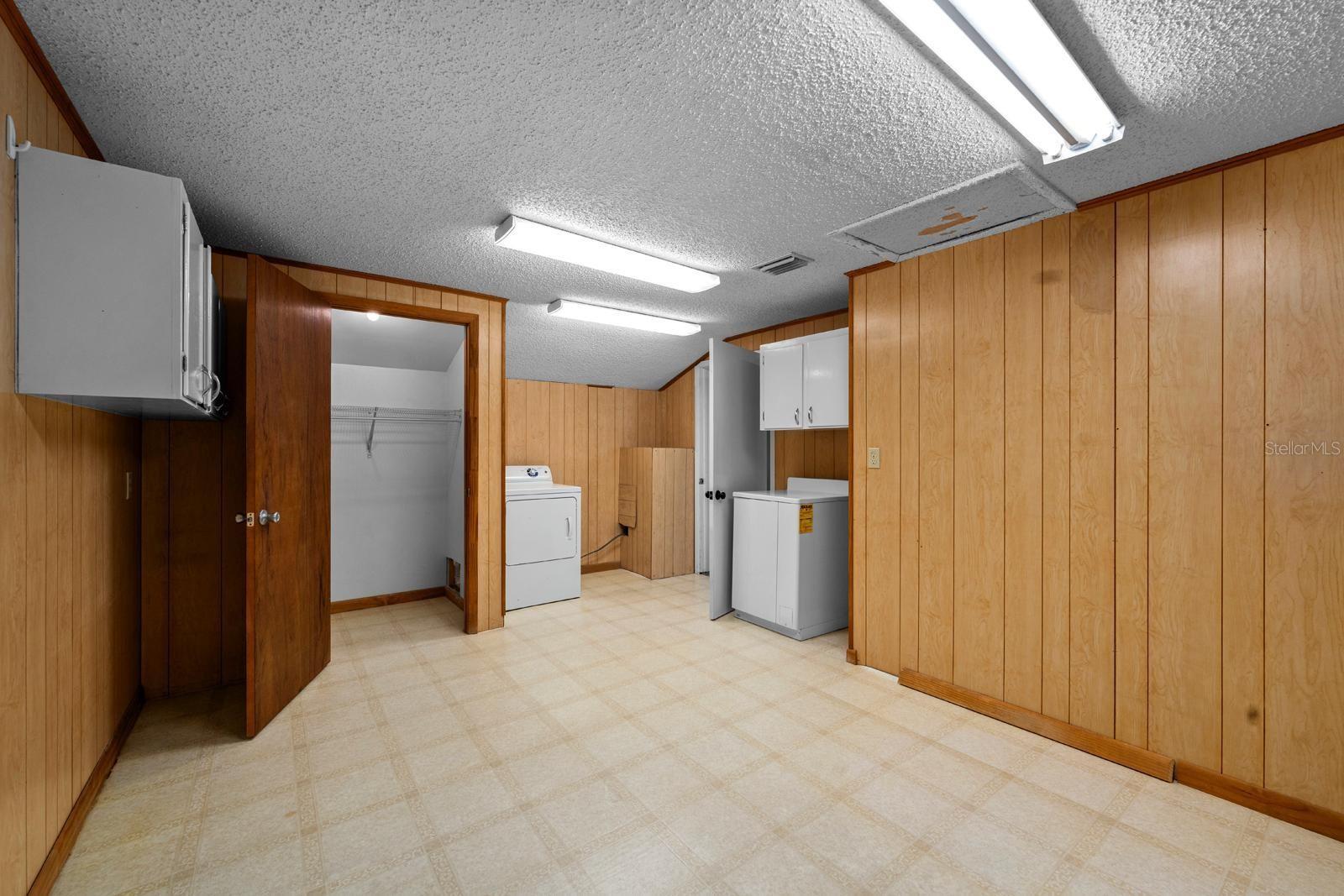 The enormous utility room has a walk-in closet, so it could be used as another bedroom OR renovated to be another bathroom. It features built-in wall cabinets, a dryer, washer hook-up, hot water heater, newer lighting, attic access, and also a smaller closet in the corner with a curtain.