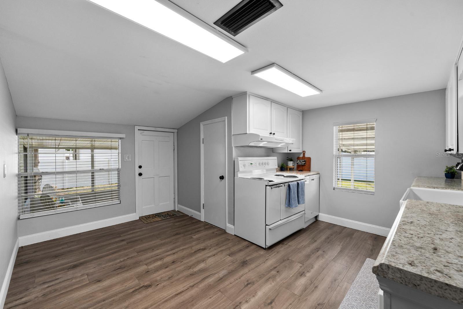 The updated kitchen features a beautiful farm sink, newer cabinets and countertops, newer appliances, the extra large range features a second oven, a range hood, new lighting, over-the-sink lighting, an updated faucet, and backsplash.