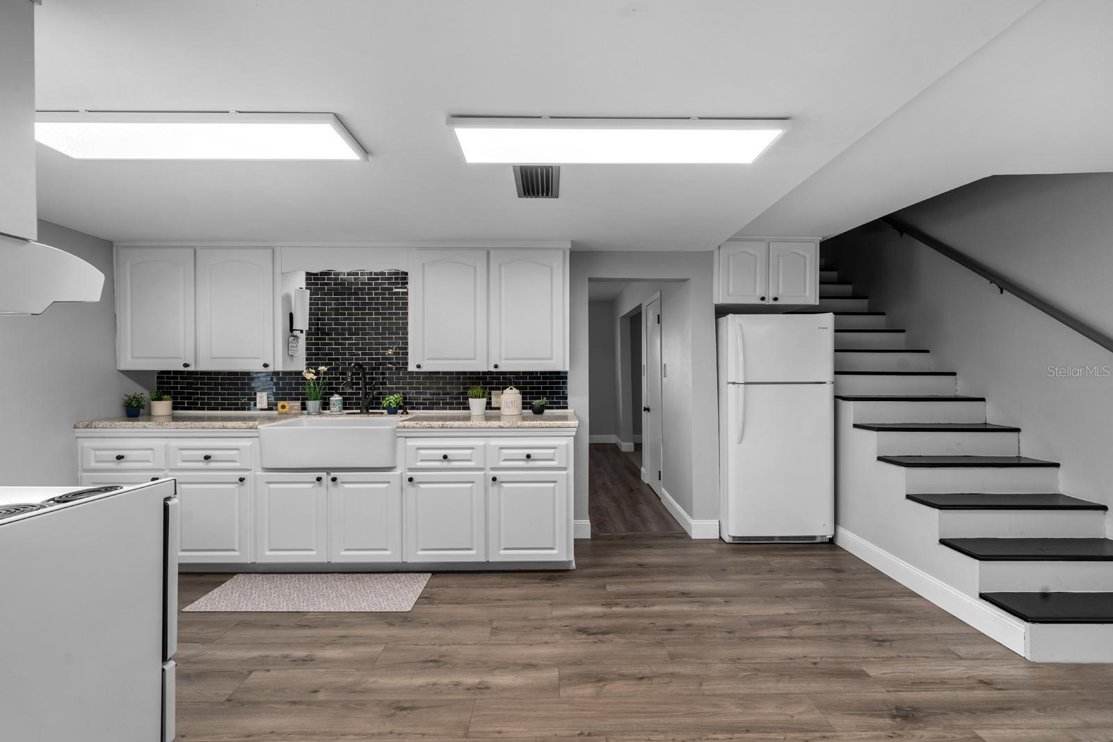 The updated kitchen features a beautiful farm sink, newer cabinets and countertops, newer appliances, the extra large range features a second oven, a range hood, new lighting, over-the-sink lighting, an updated faucet, and backsplash.