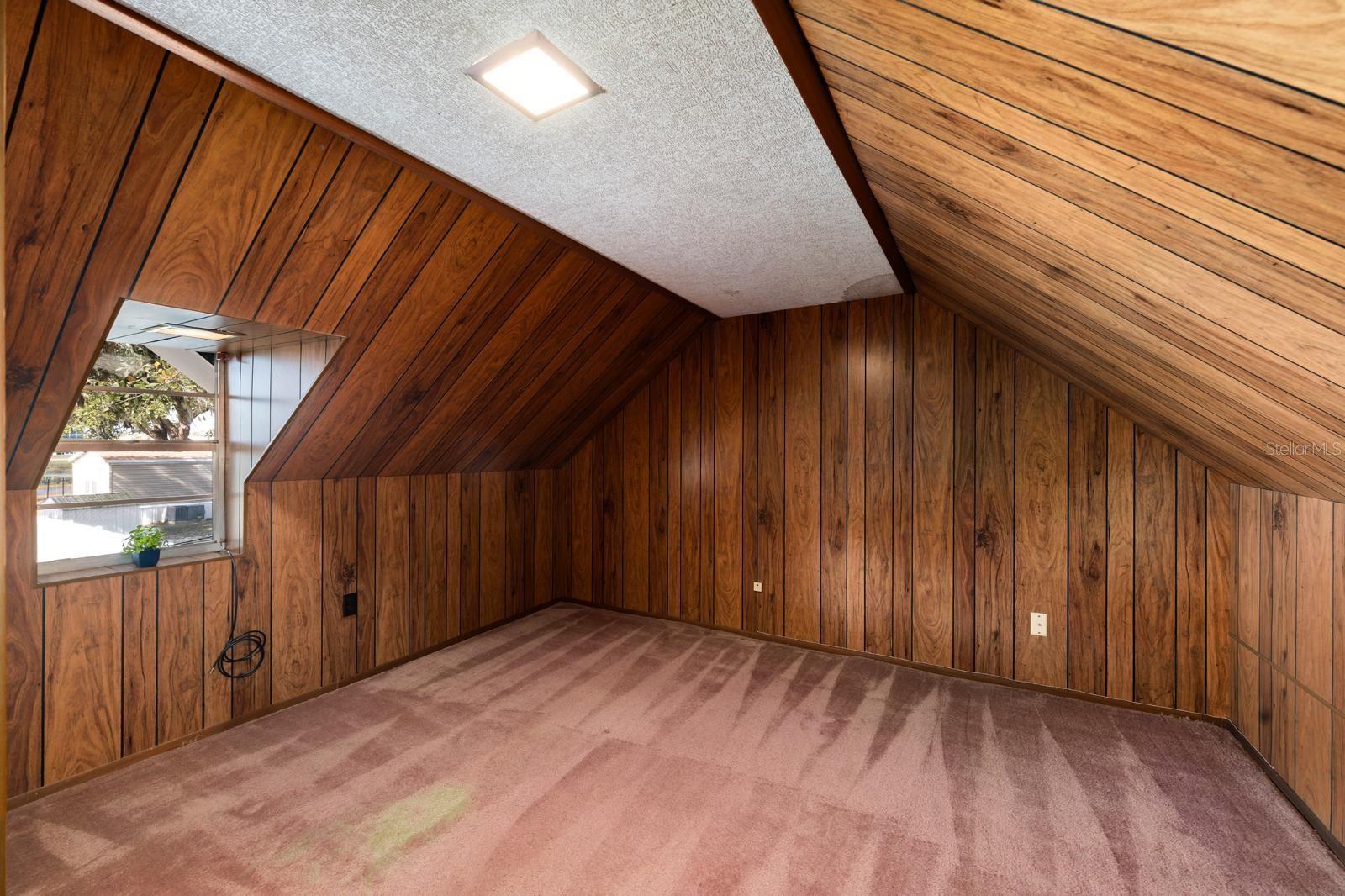 One of the upstairs bedrooms has some sweet-looking, aged-pink carpet and beautiful, 70's style paneling.