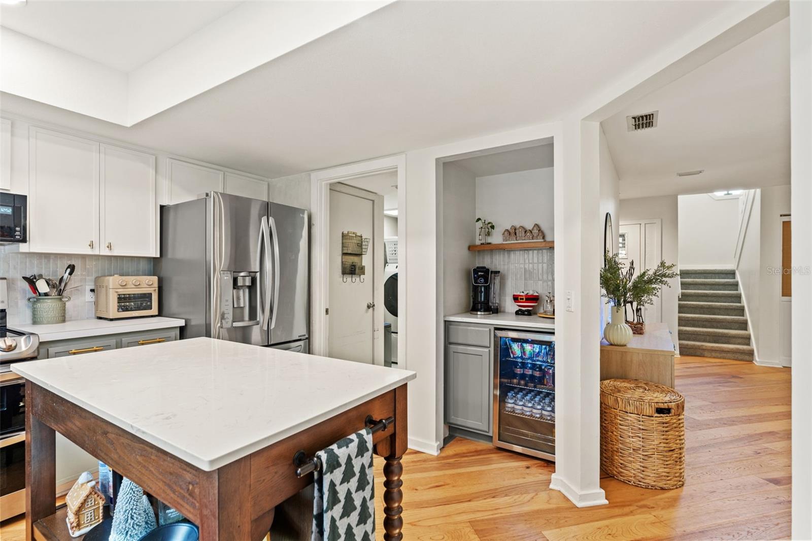 Center island provides additional prep space and seating, framed by abundant cabinetry and natural light from the window over the sink.