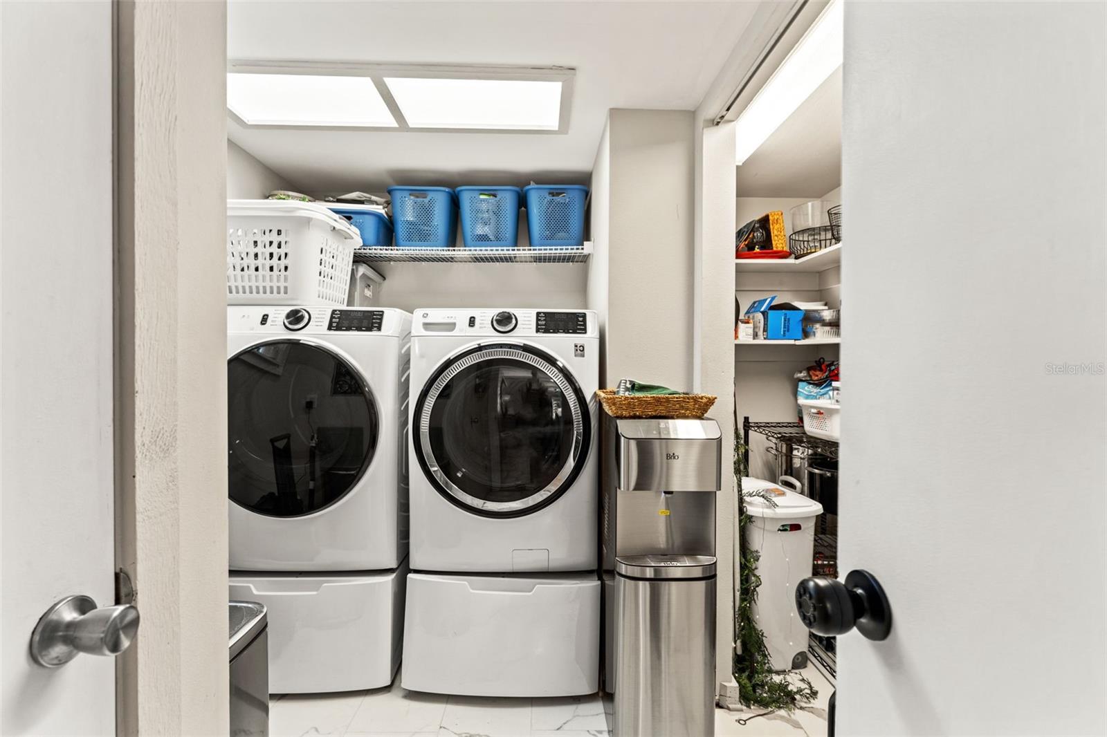 Dedicated laundry room with washer and dryer, shelving, and tile flooring for durability and easy maintenance. PLUS walk-in PANTRY!