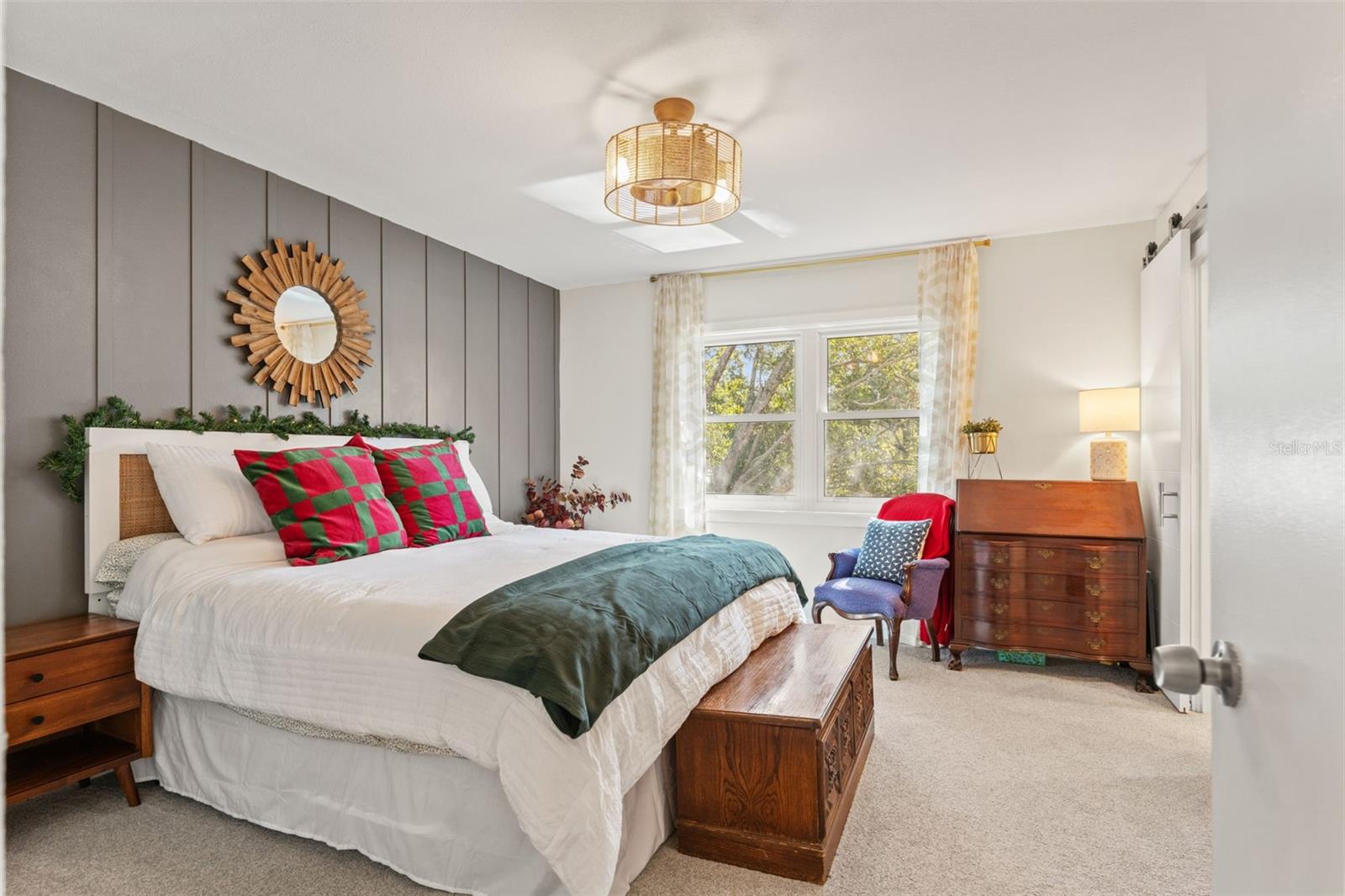 Spacious primary bedroom with neutral finishes, soft carpeting, and abundant natural light from large windows.
