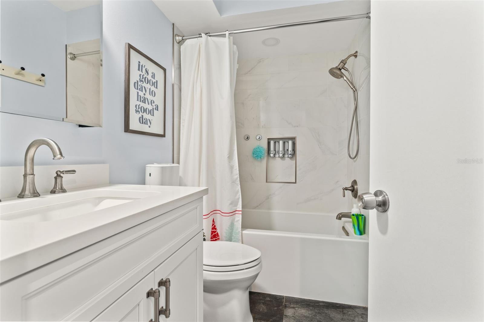 Updated full bath with tub/shower combination, tile surround, modern vanity, and clean, neutral finishes.