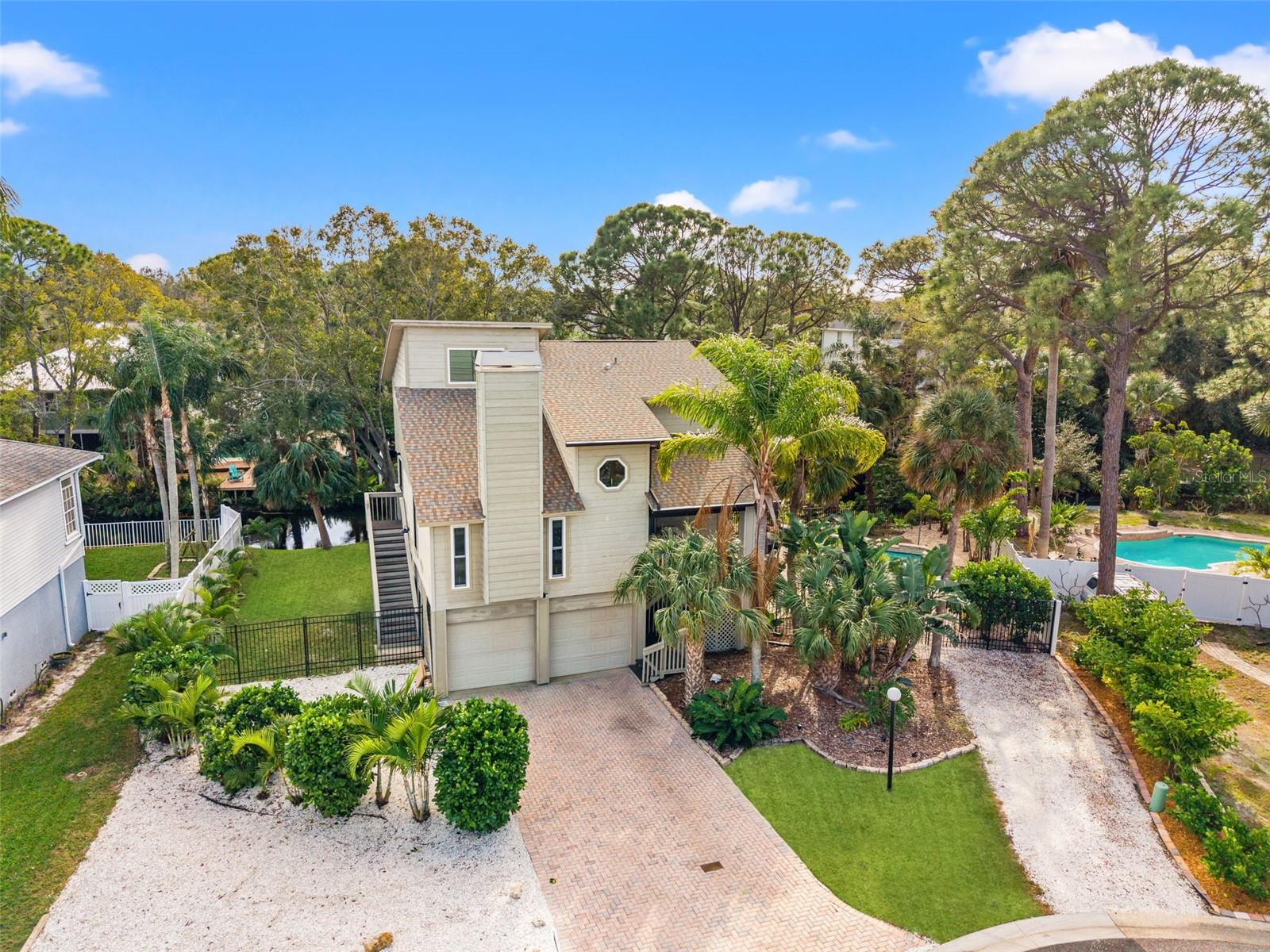 Aerial view showcases the home’s placement within a quiet neighborhood setting with mature tree canopy.