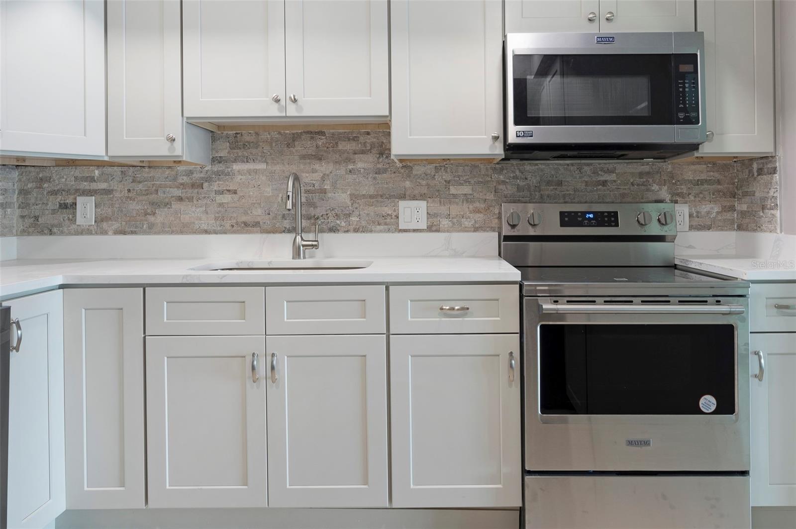 Everything is NEW. Beautiful light gray cabinets, beautiful quartz counters, new stove, new microwave.
