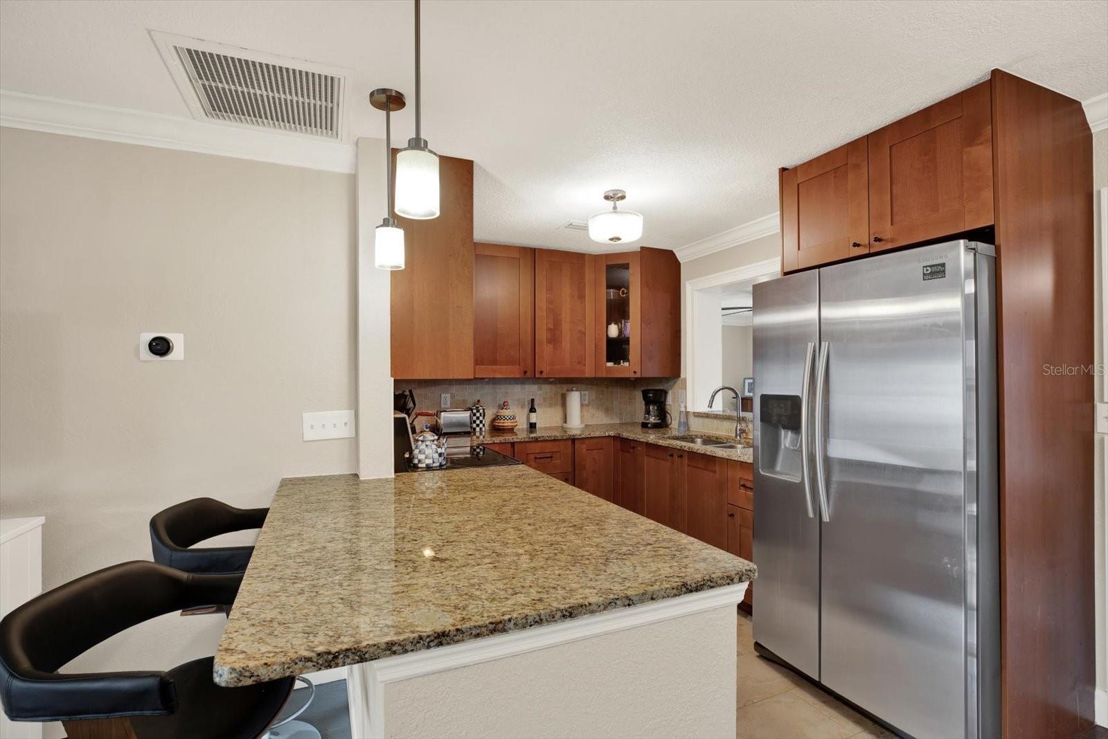 The kitchen dons granite countertops and solid wood cabinetry and stainless steel appliances