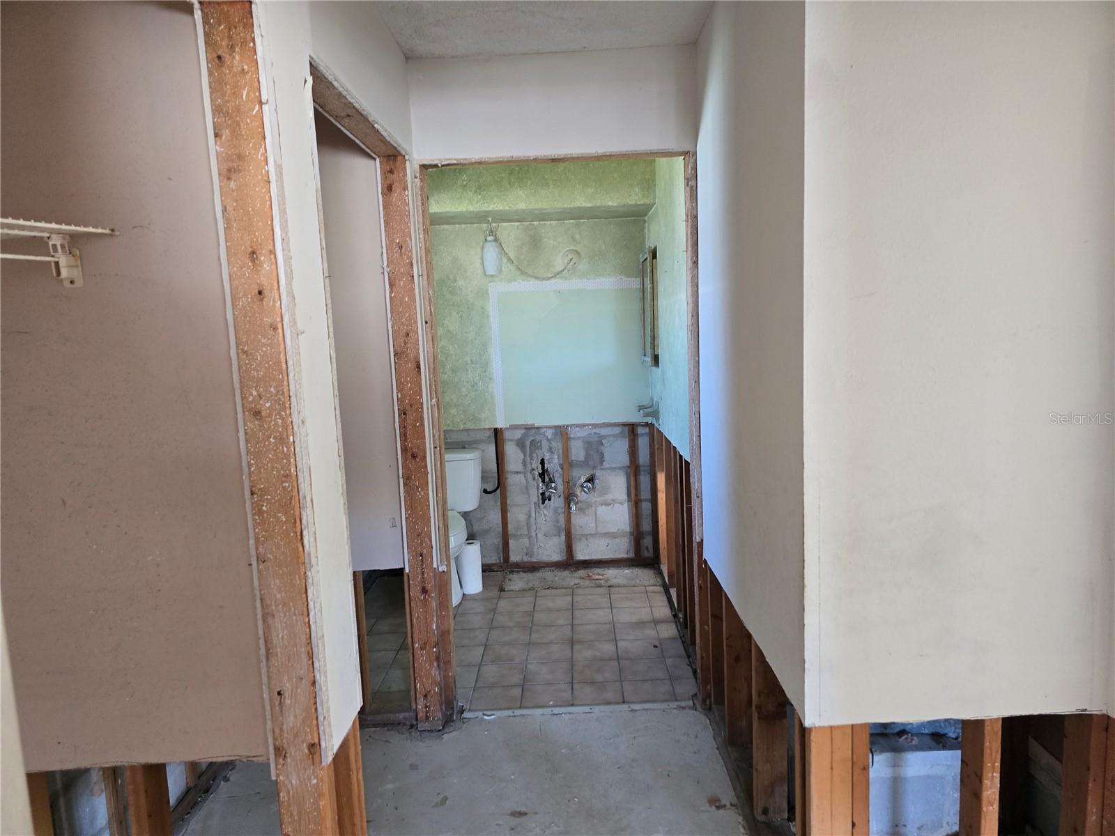 Hallway with 2 closets which leads to half bath and garage