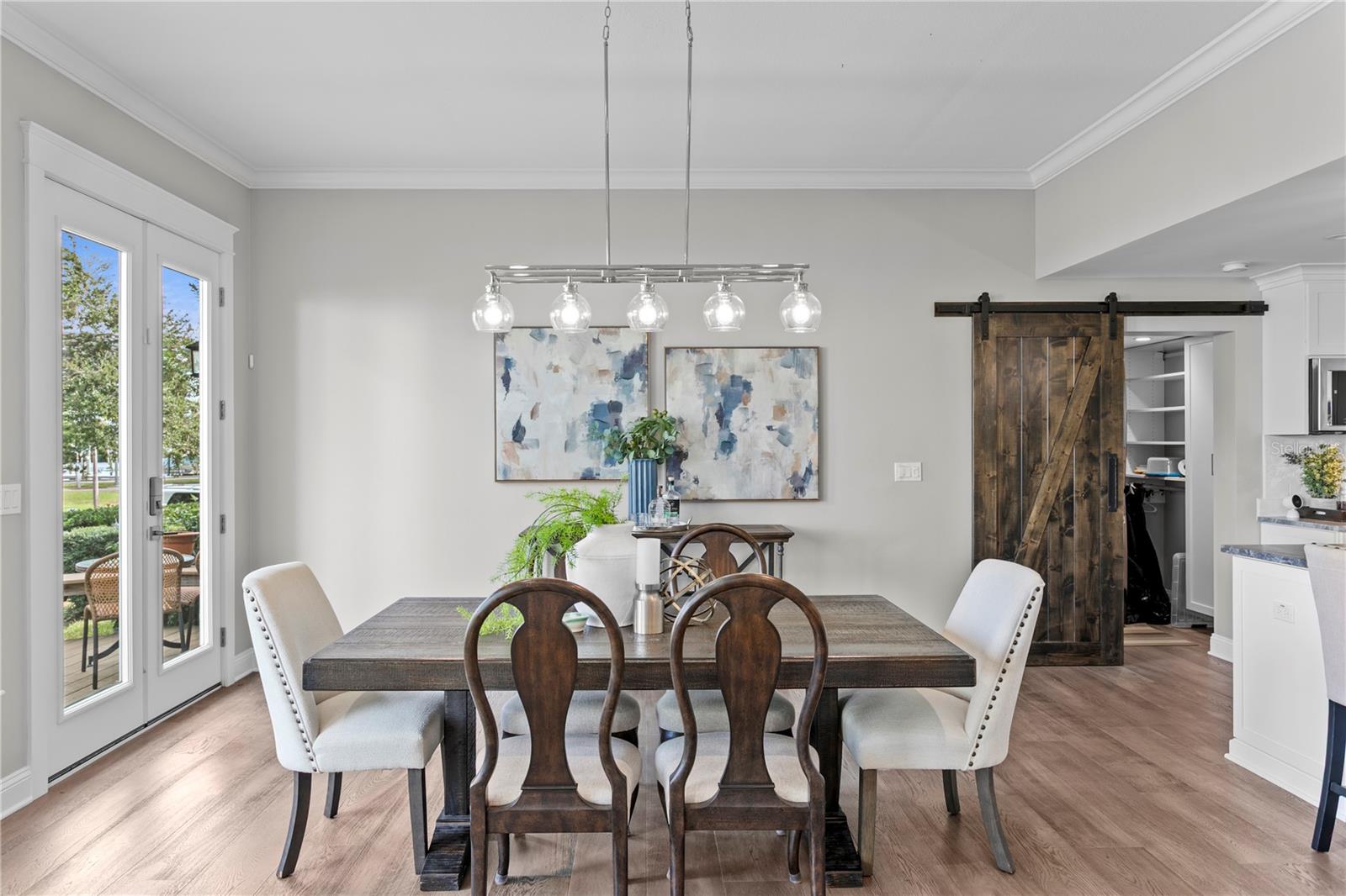 Open dining with convenience of centrally located laundry privatized by classy barn door