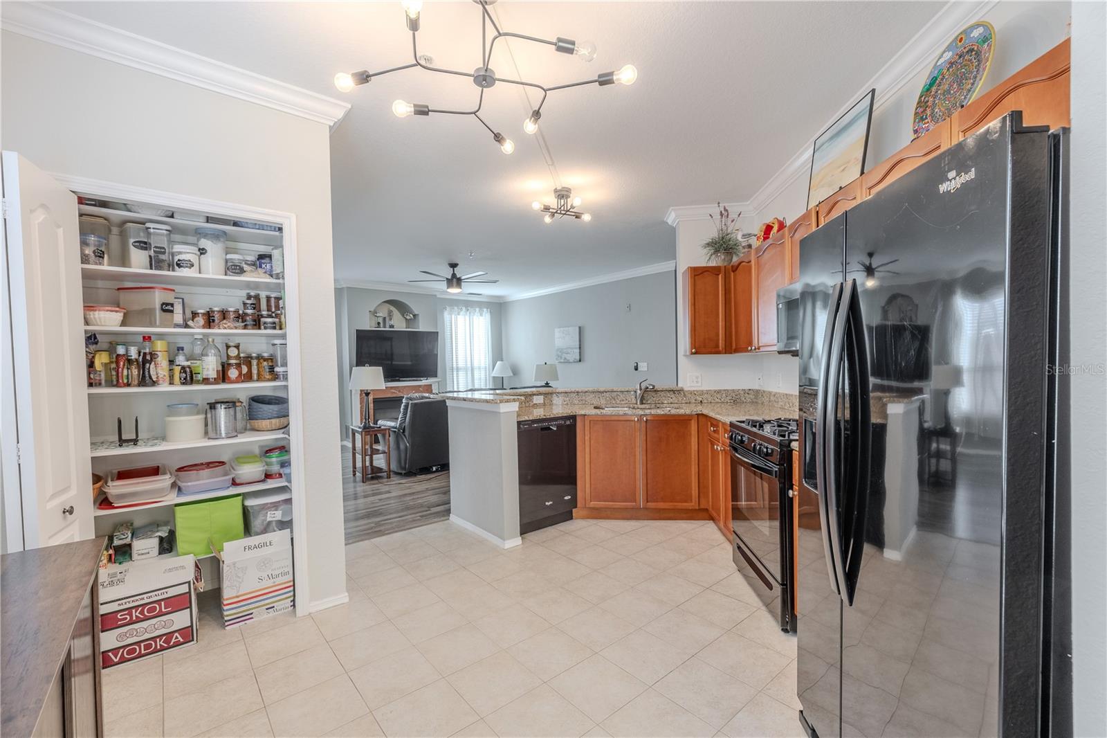 Natural light fills this eat-in kitchen area, featuring a large window, tile flooring, modern lighting, and sliding glass doors that open to the private balcony for easy indoor–outdoor living.