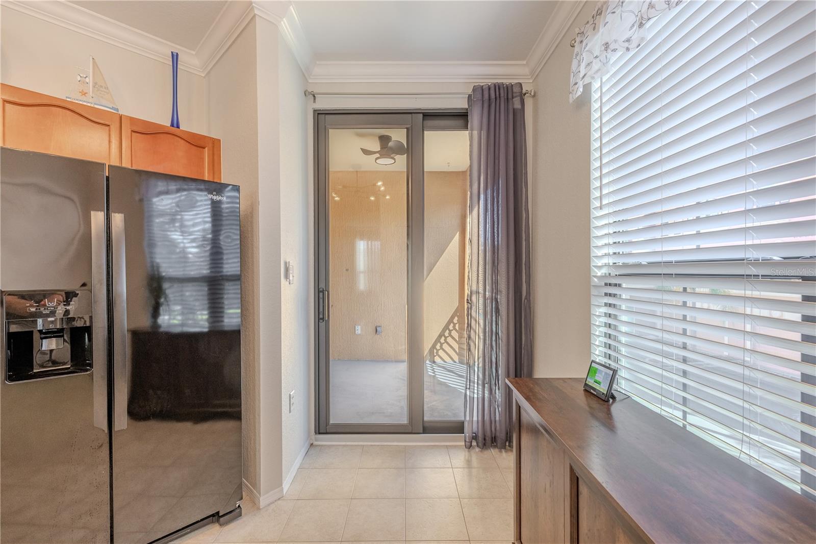 This view showcases the open-concept kitchen seamlessly flowing into the living area, featuring granite countertops, warm wood cabinetry, stainless appliances, modern lighting, and a layout designed for effortless entertaining.