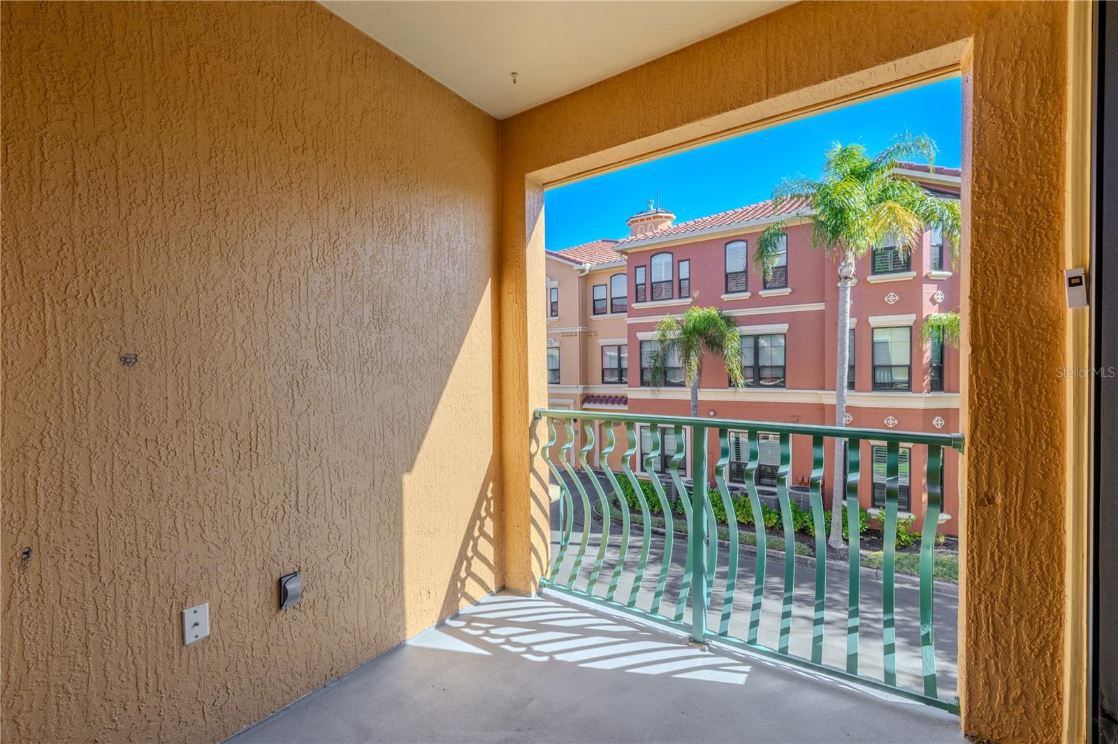 Primary bedroom retreat featuring sliding glass doors to the private balcony, soft neutral tones, modern lighting, and easy access to the main living area, creating a bright and comfortable space to unwind.