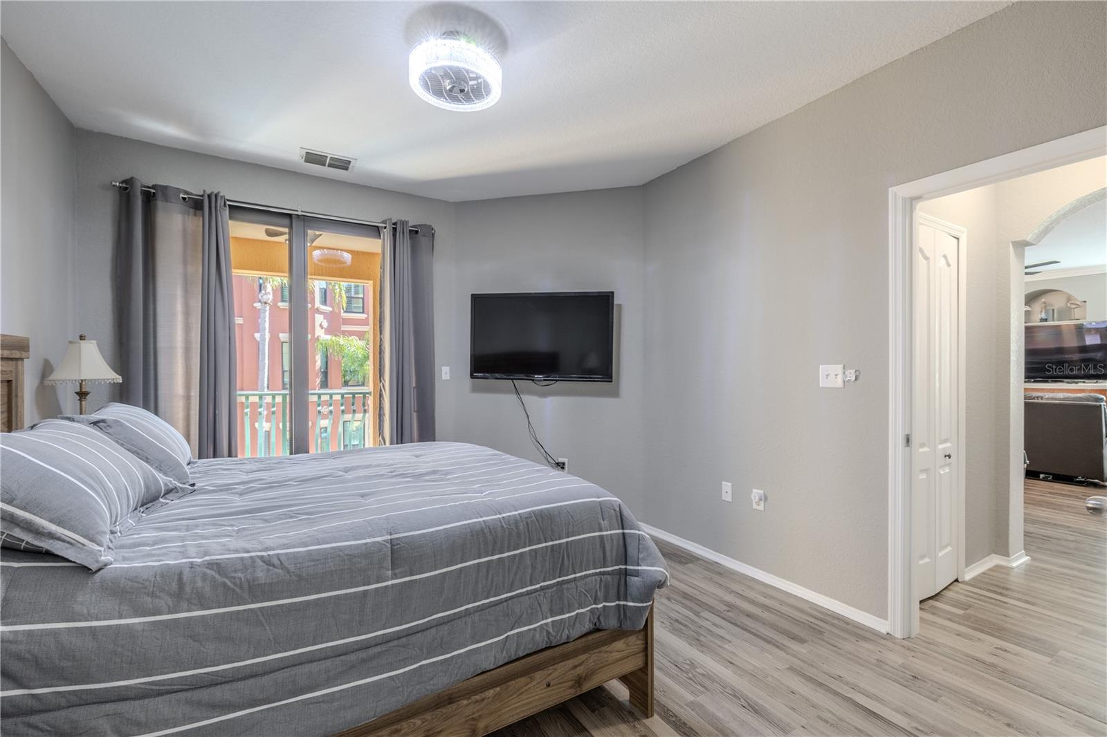Alternate view of the primary en-suite showcasing the glass-enclosed walk-in shower, soaking tub with decorative tile accents, and expansive vanity with ample counter space and storage.