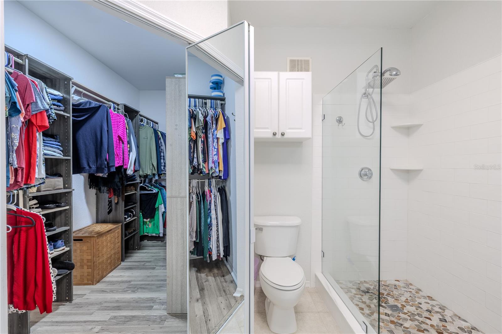 This view highlights the seamless flow from the open living and dining area into the private hallway leading to the bedrooms, showcasing the unit’s airy layout, cohesive flooring, and thoughtful separation of living and sleeping spaces.