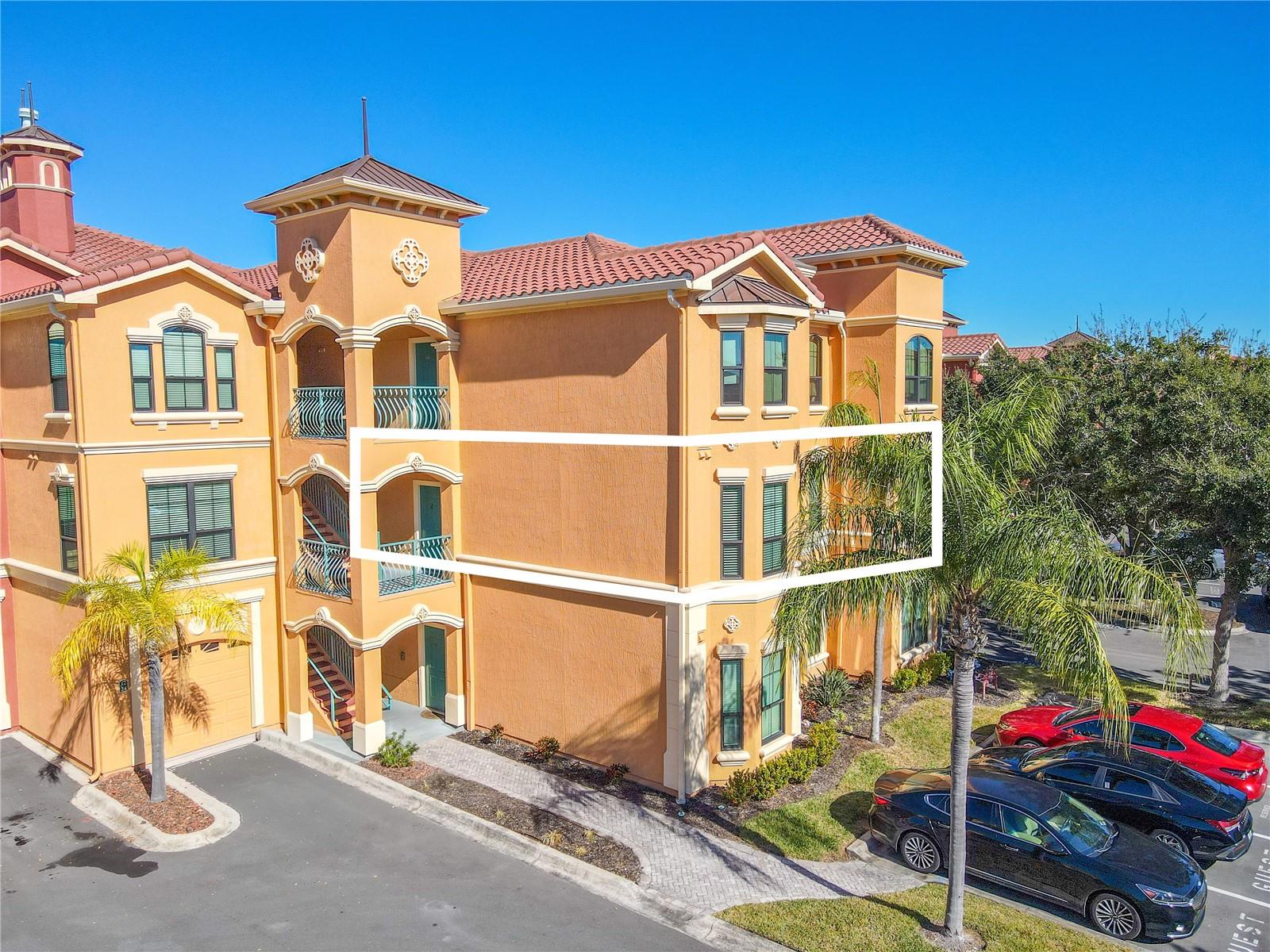 An open, light-filled living area features crown molding, laminate flooring, a modern ceiling fan, and a cozy gas fireplace, flowing seamlessly into the dining space for effortless everyday living and entertaining.