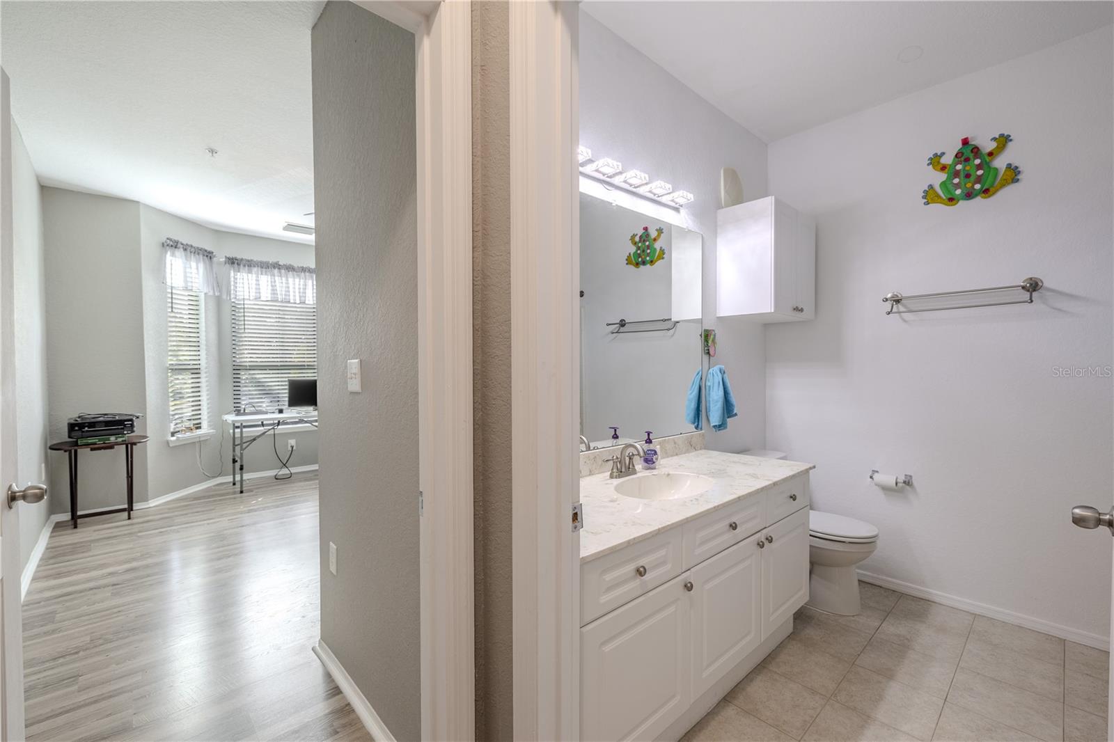 This clean and well-appointed tub/shower combination features crisp white tile surround, built-in shelving, updated fixtures, and a bright, beach-inspired aesthetic that complements the home’s coastal feel.