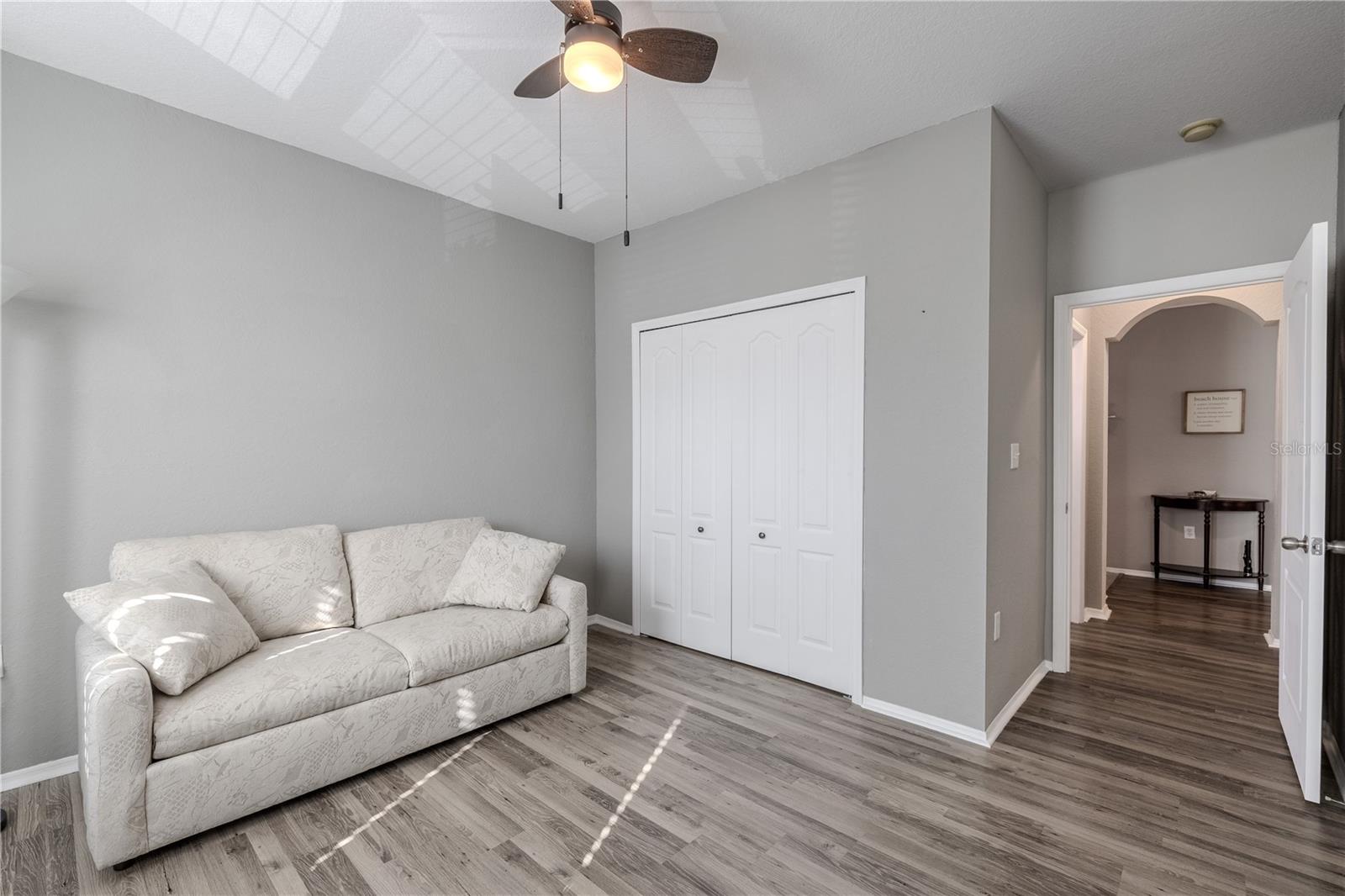 This bright second bathroom features a wide vanity with a solid-surface countertop, ample cabinetry, a full-size tub/shower combination, and cheerful natural light, making it ideal for guests or secondary bedrooms.