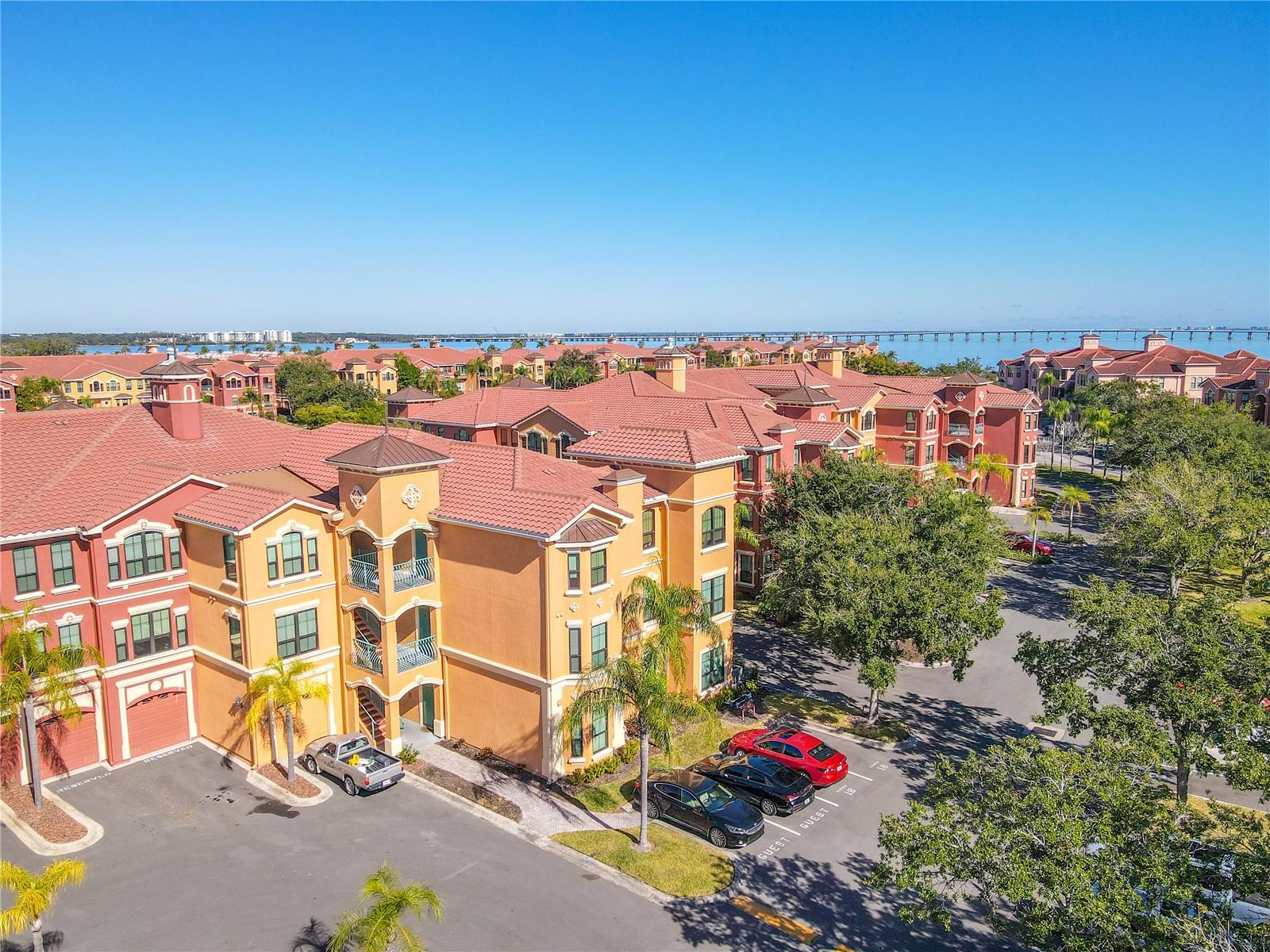 Resort-style amenities include beautifully maintained tennis courts set against a backdrop of palm trees and Mediterranean-inspired architecture, perfect for an active Florida lifestyle.