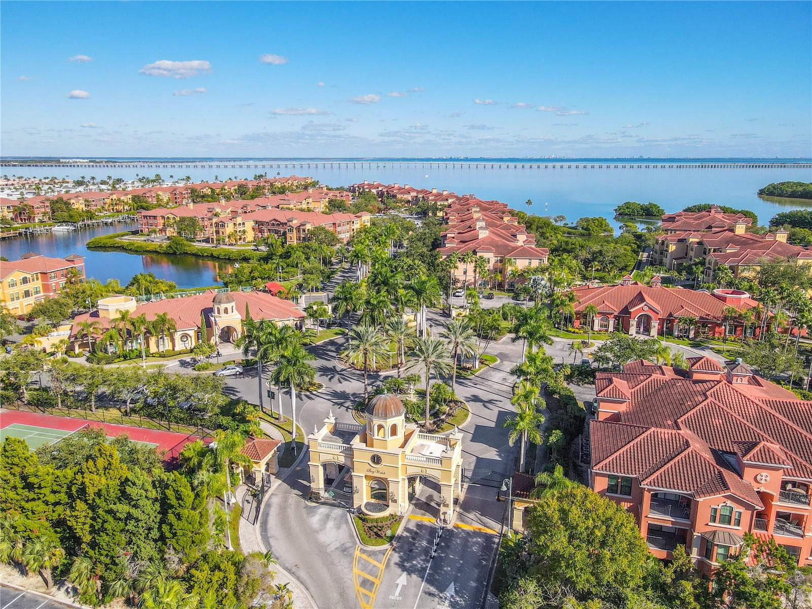 The elegant waterfront clubhouse serves as the heart of the community, offering a grand gathering space framed by palm-lined paths, serene water views, and classic Mediterranean charm.