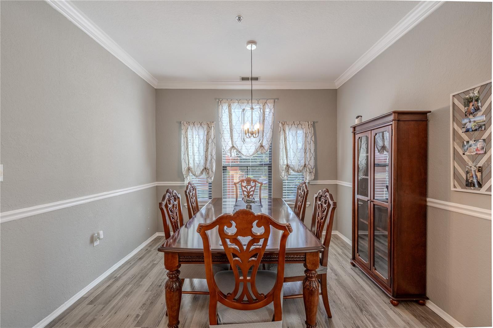 This view highlights the spacious kitchen which showcases granite countertops with a breakfast bar, warm wood cabinetry, stainless appliances, modern lighting, and easy access to the private terrace, ideal for both casual dining and entertaining.