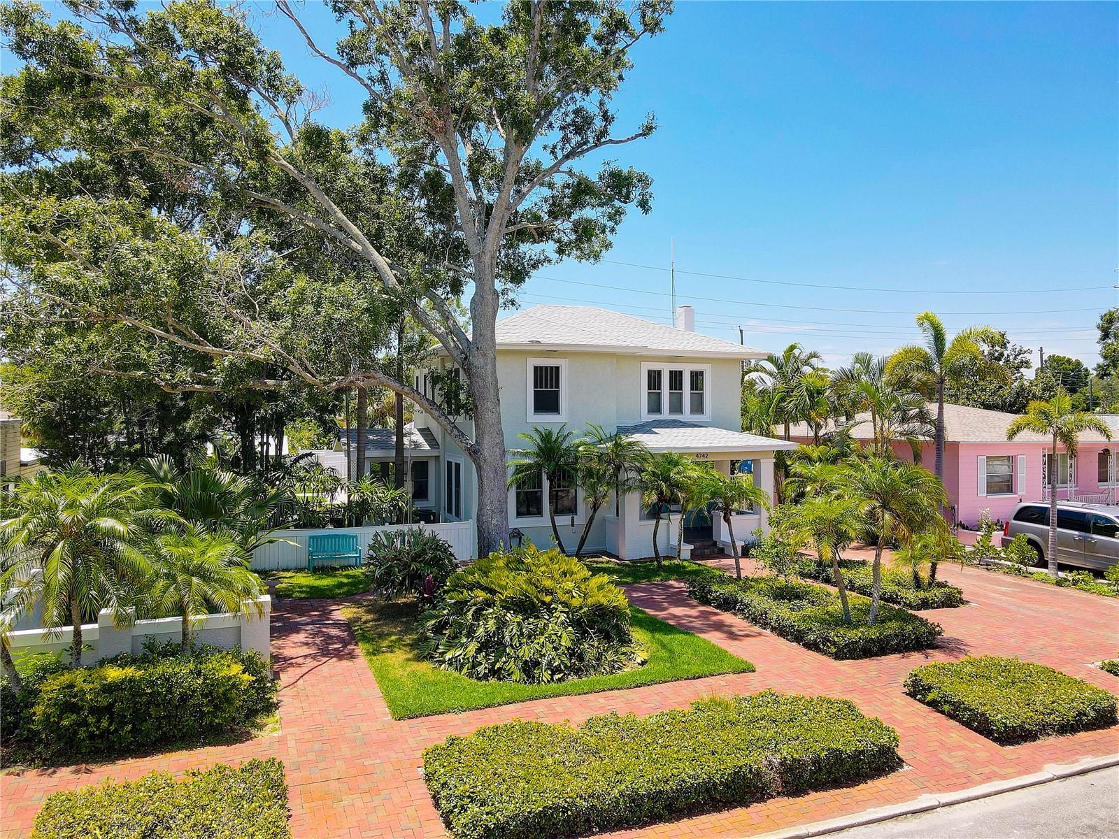 Front view with 3-car driveway on right, path to backyard on left