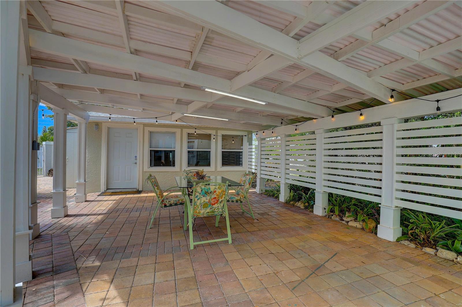 Covered patio. Guest quarters in back, privacy fence on right.