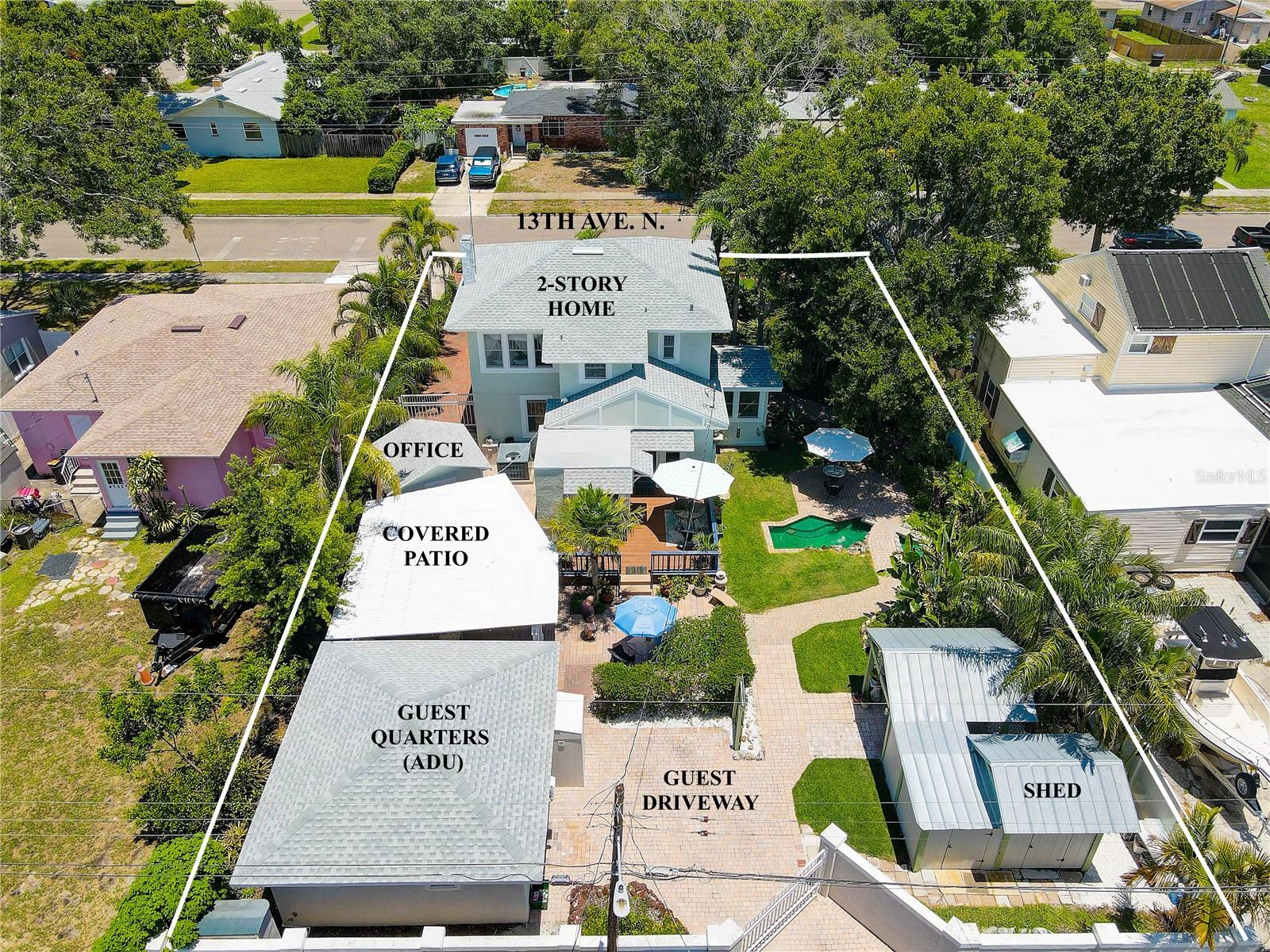 Main home at top of photo, then 10x10 air-conditioned office/shed, covered patio, guest quarters with its own private driveway off the alley, and storage sheds at bottom right.
