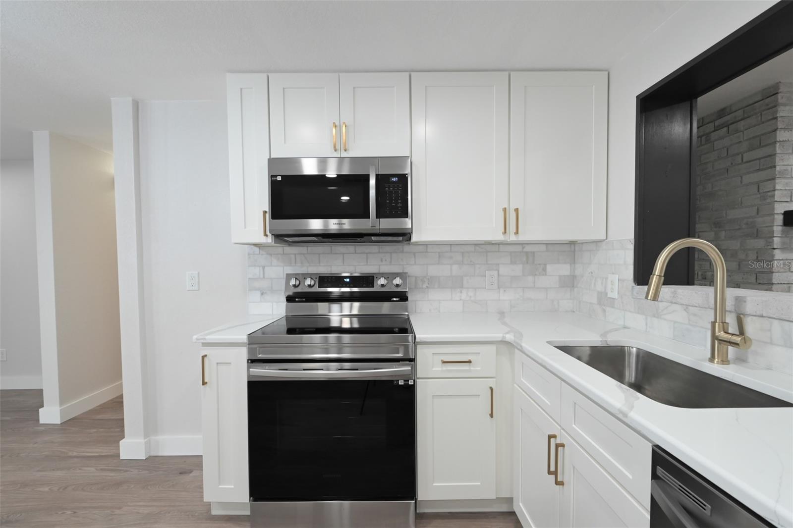Stove & Microwave. You can see the fireplace through kitchen open window.