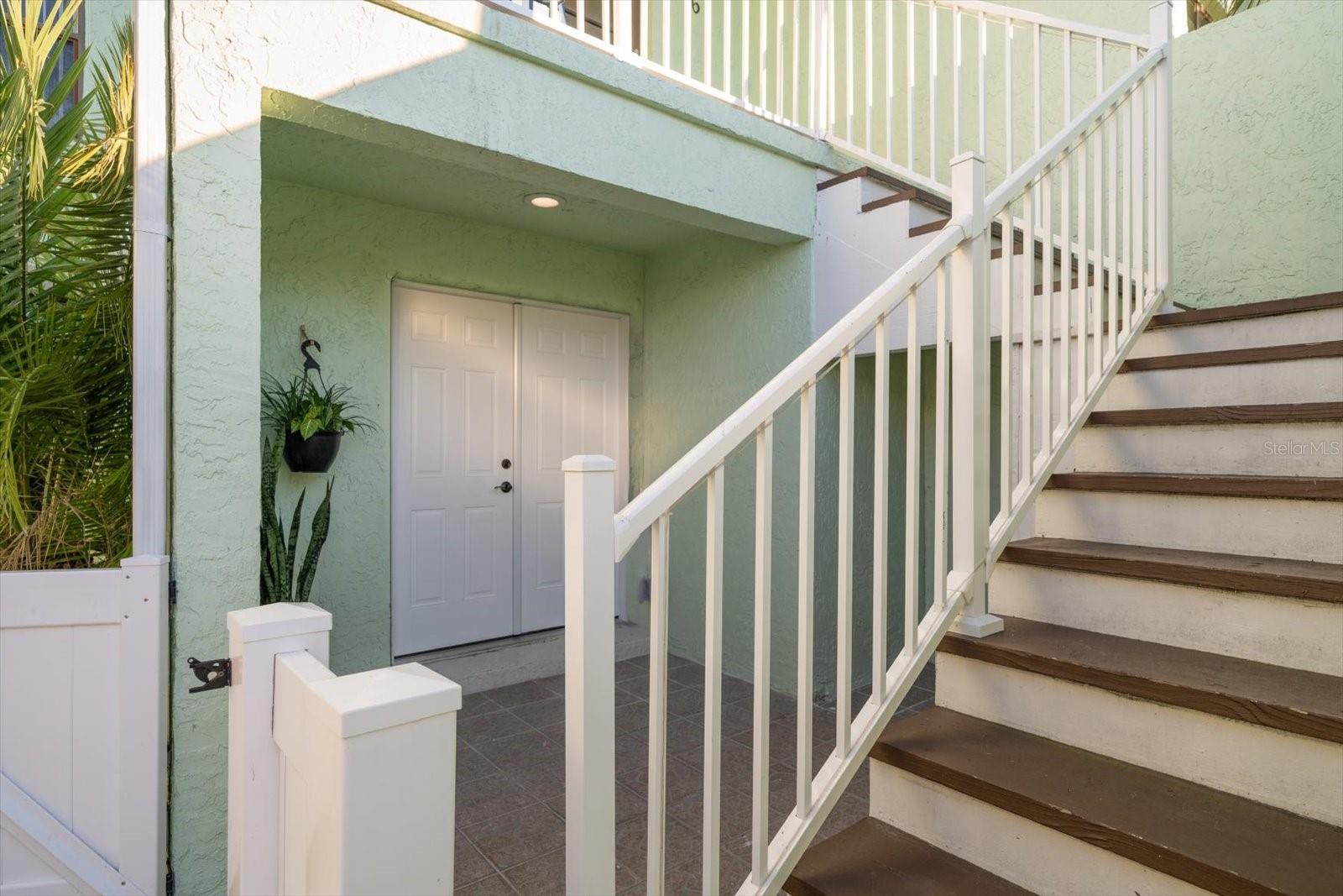 Private entry with additional storage under staircase.