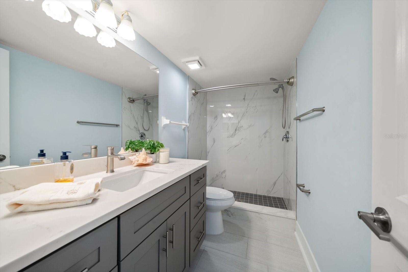 Attractively remodeled bathroom with walk in shower.