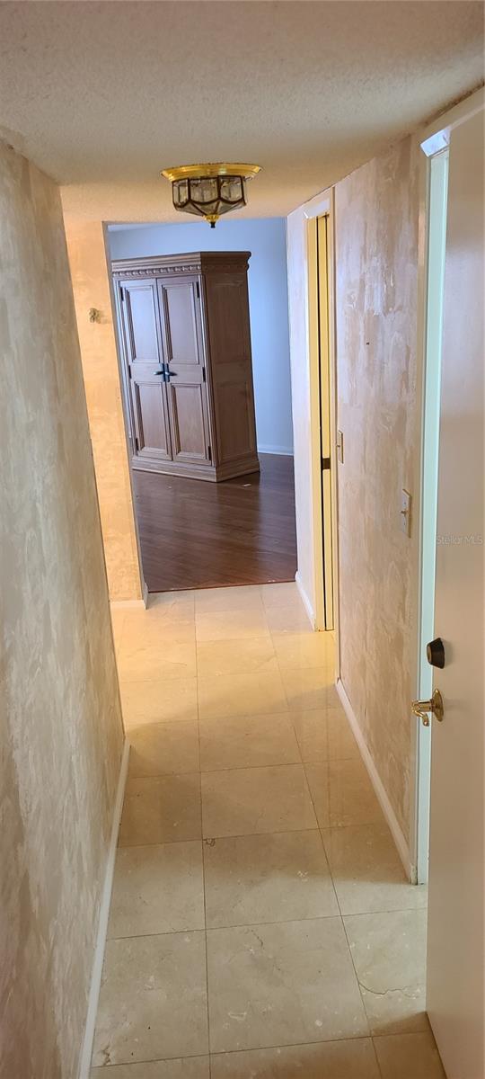 Hallway to Primary with EnSuite on the Left and His and Her Closets on the Right