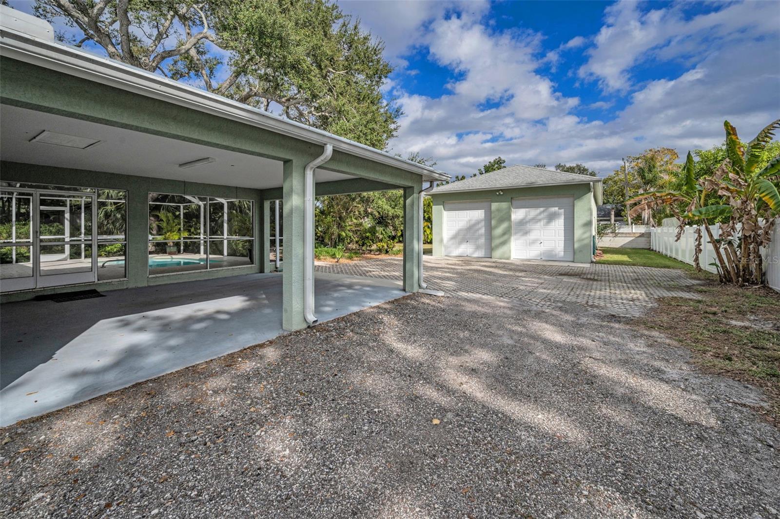 Offering a two-car carport providing convenient shelter for your vehicles, while an expansive detached three-car garage boasts a high ceiling that can accommodate a large boat or RV.