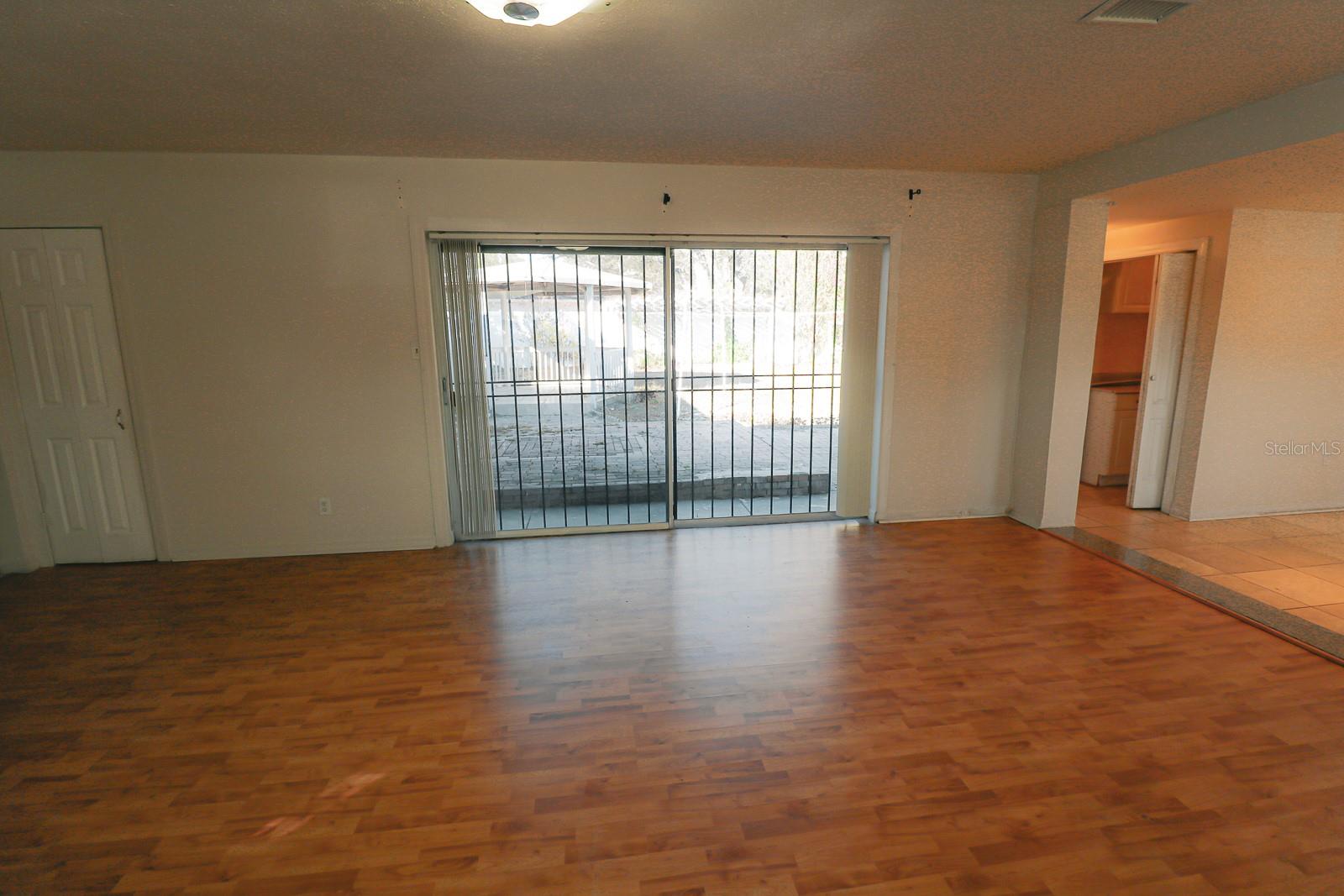Spacious living room with large sliding glass door providing view of backyard.