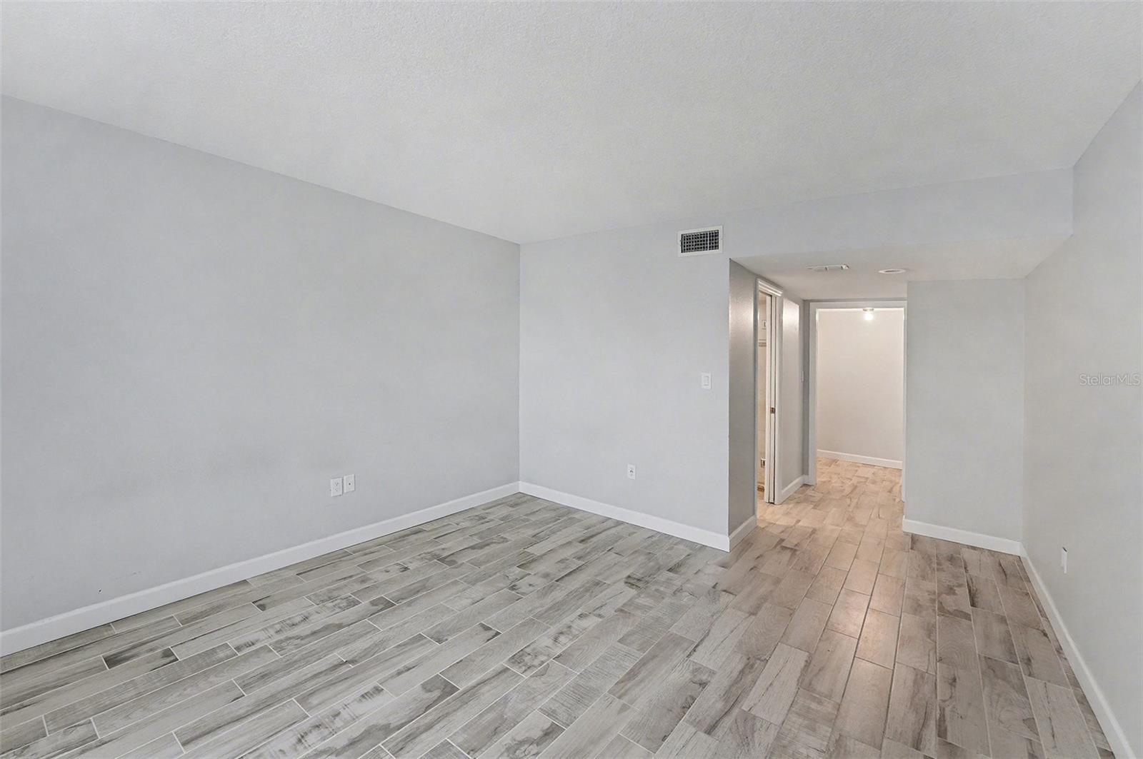 Primary suite with beautiful tile floors, a walk in closet, and full private bath.