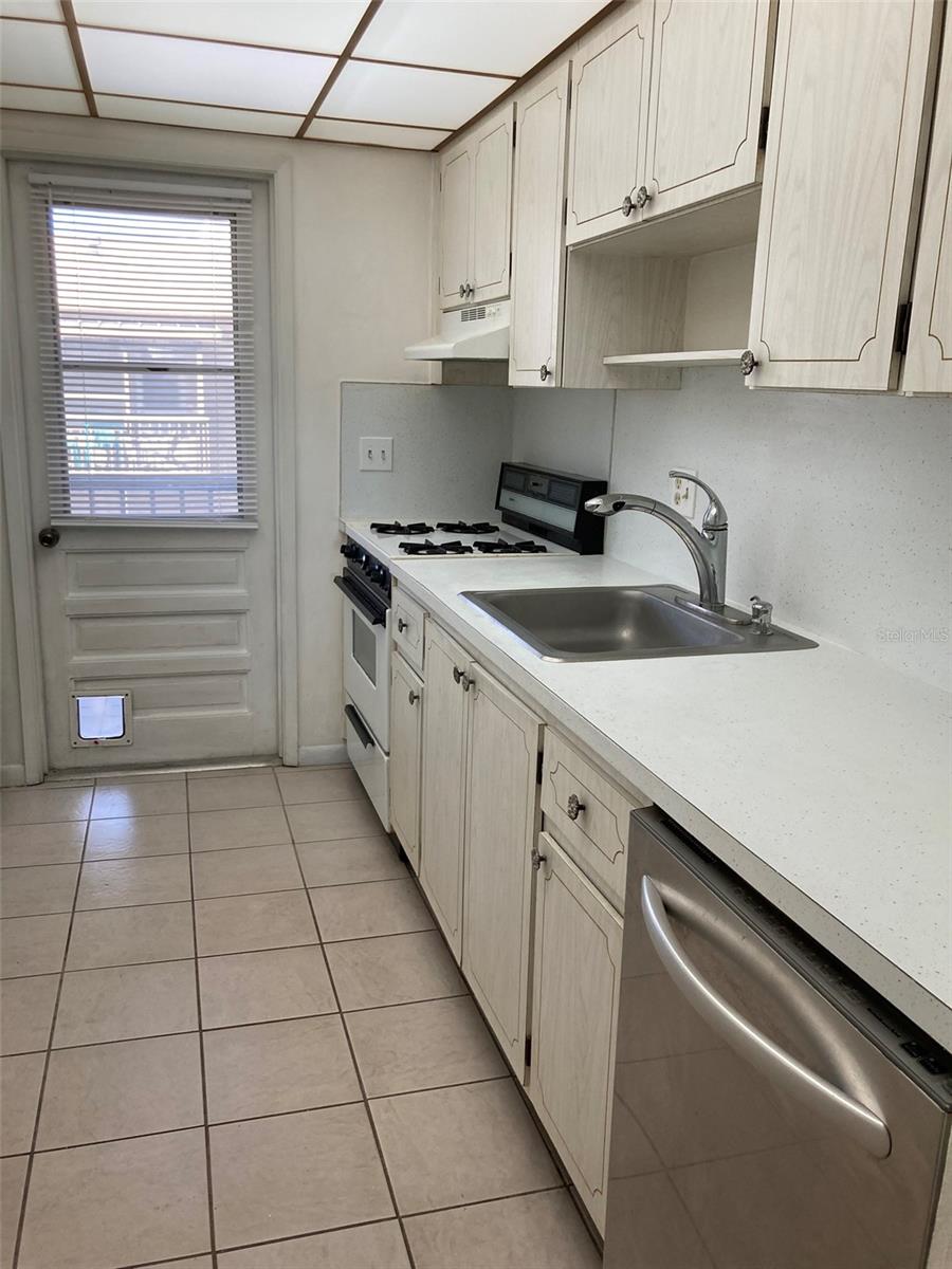 Dishwasher, gas range and balcony access.