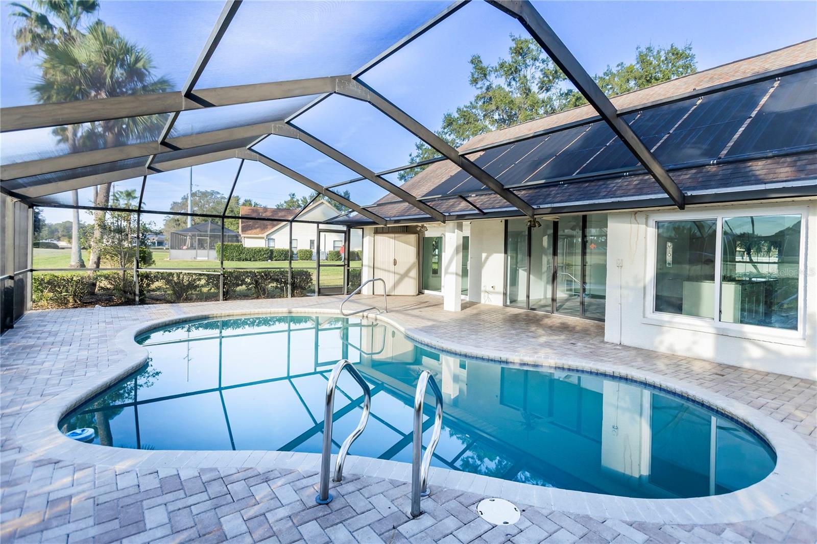 Pool, ceiling fans on deck, solar panels to heat pool, new screening on pool cage, door on either side of enclosure leading to yard, beautiful view from inside of home