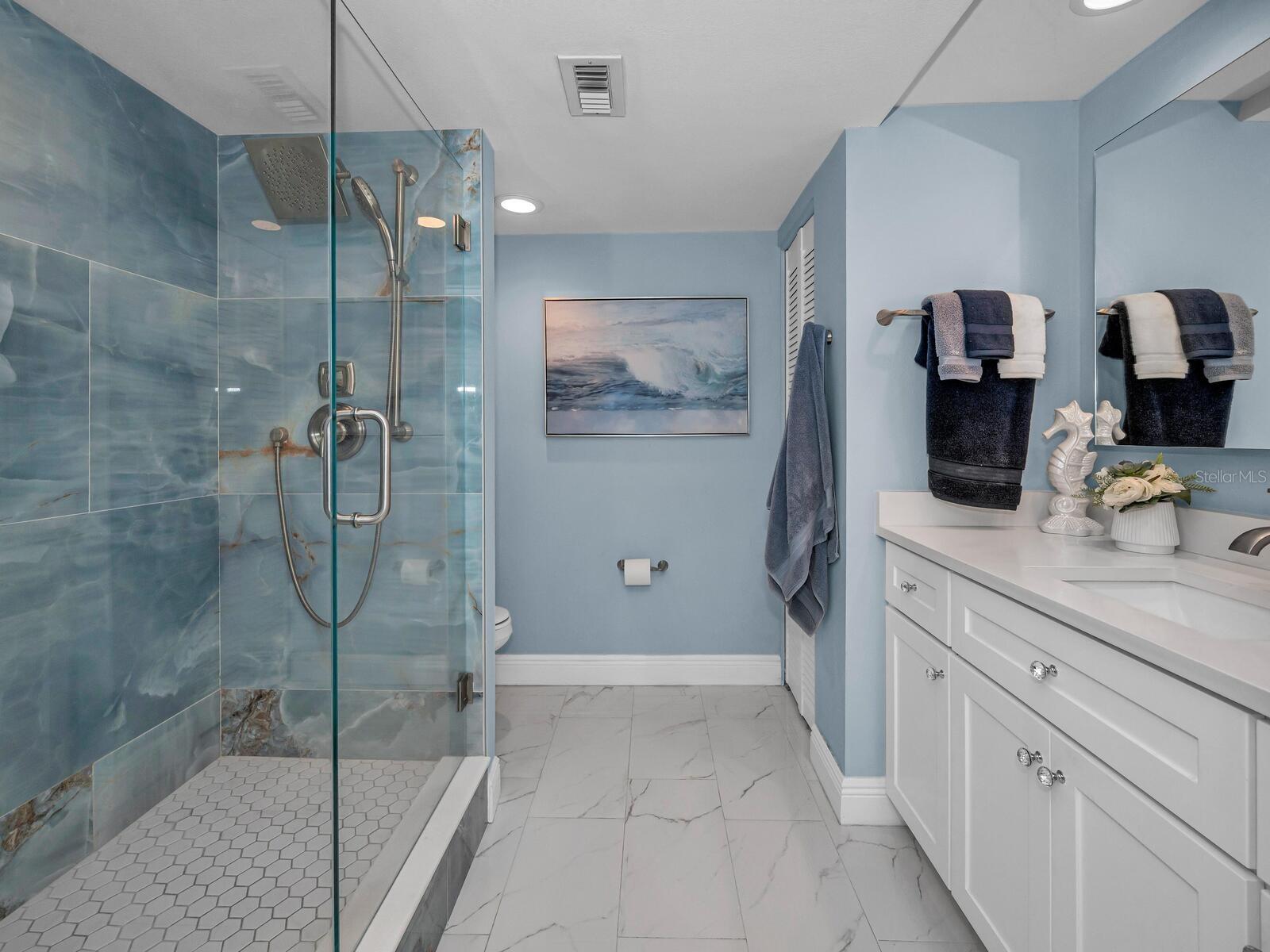 Modern baths that boast a relaxed harmony with wood cabinetry, quartz & tiled surfaces, Seamless Glass, accent fixtures & More!